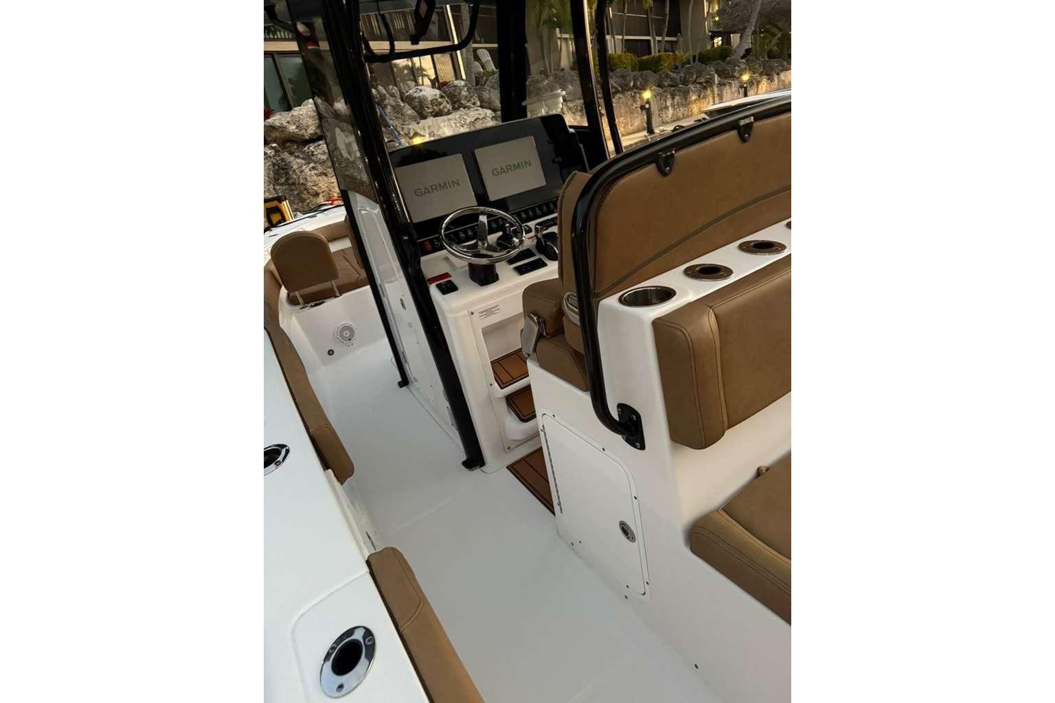 2021 Sea Hunt Gamefish 30 Forward Seating boat interior with Garmin displays and brown seating.