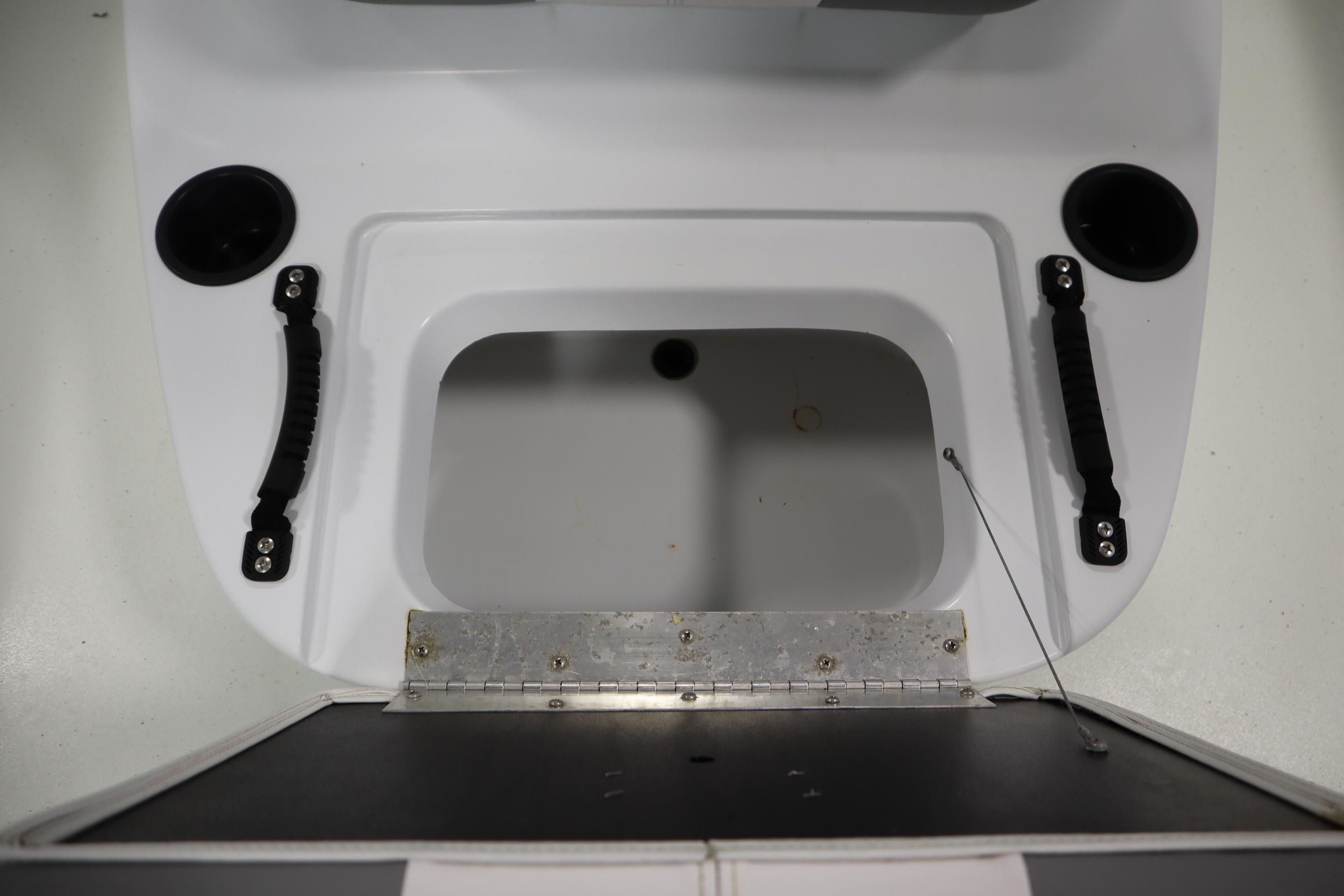 2022 Crestliner 2200 CC boat storage compartment with handles and cup holders.