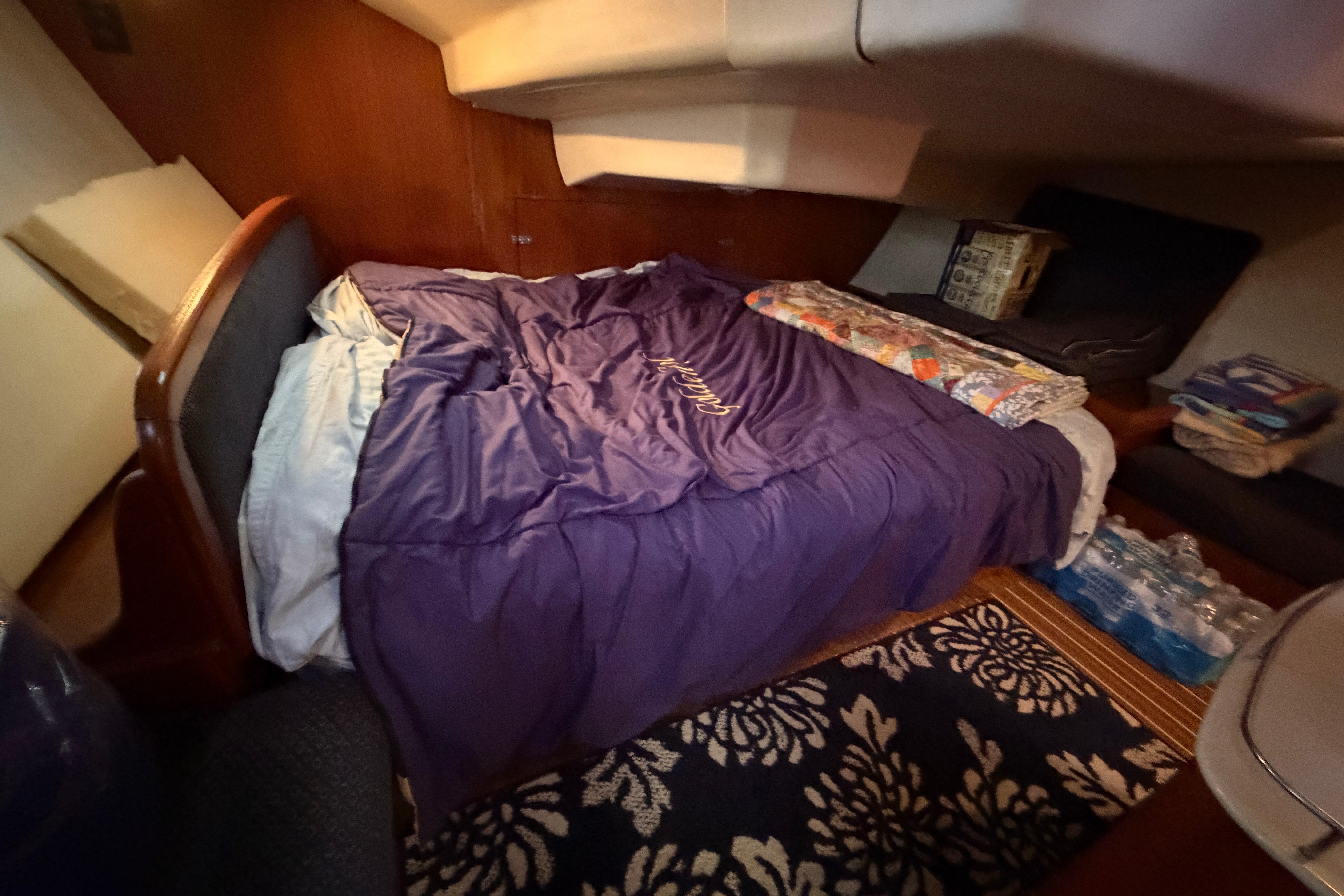 Cozy cabin interior of 2005 Hunter 38 sailboat with bed and storage.