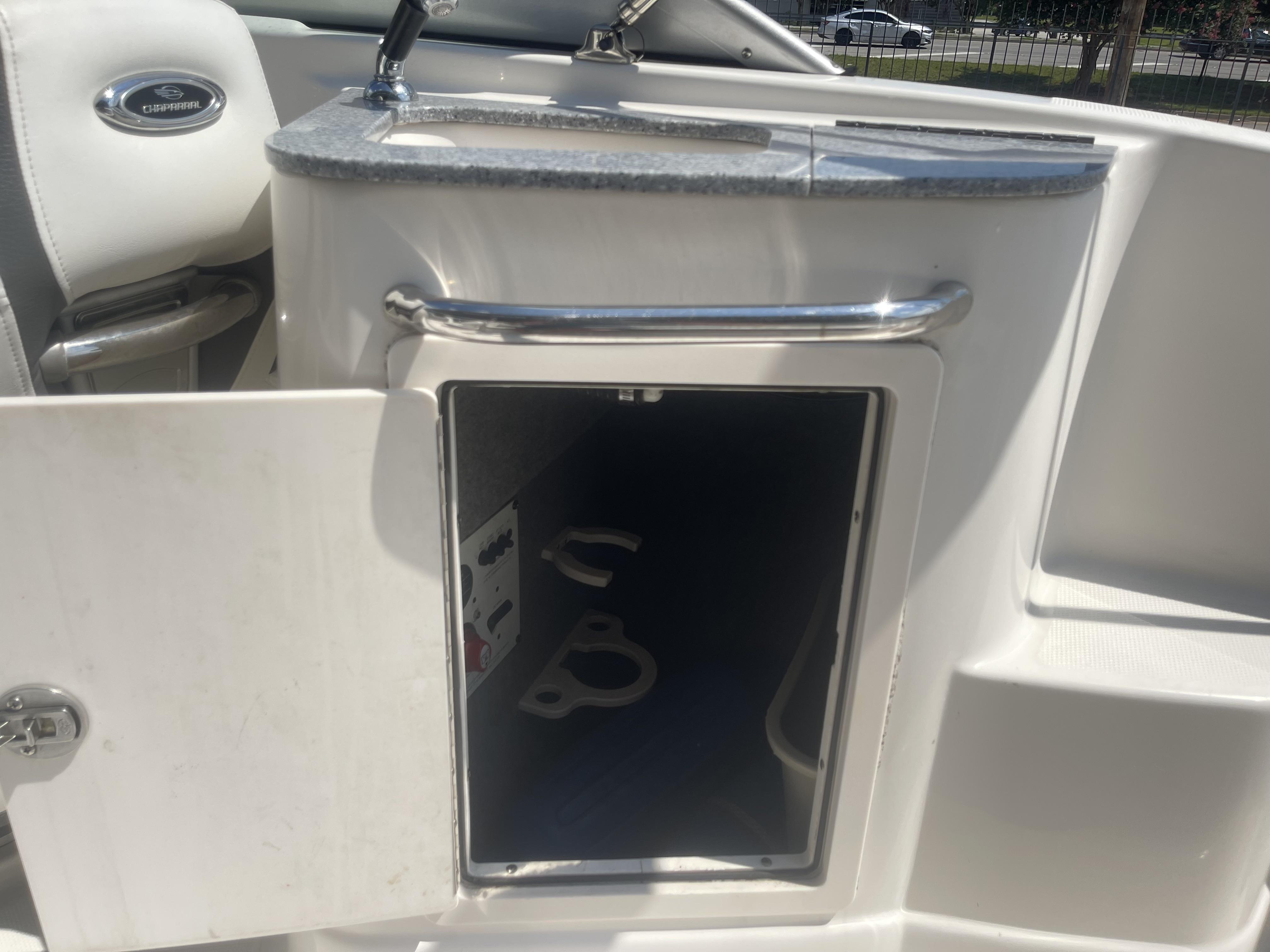 2014 Chaparral Sunesta 224 boat interior storage compartment with open door.