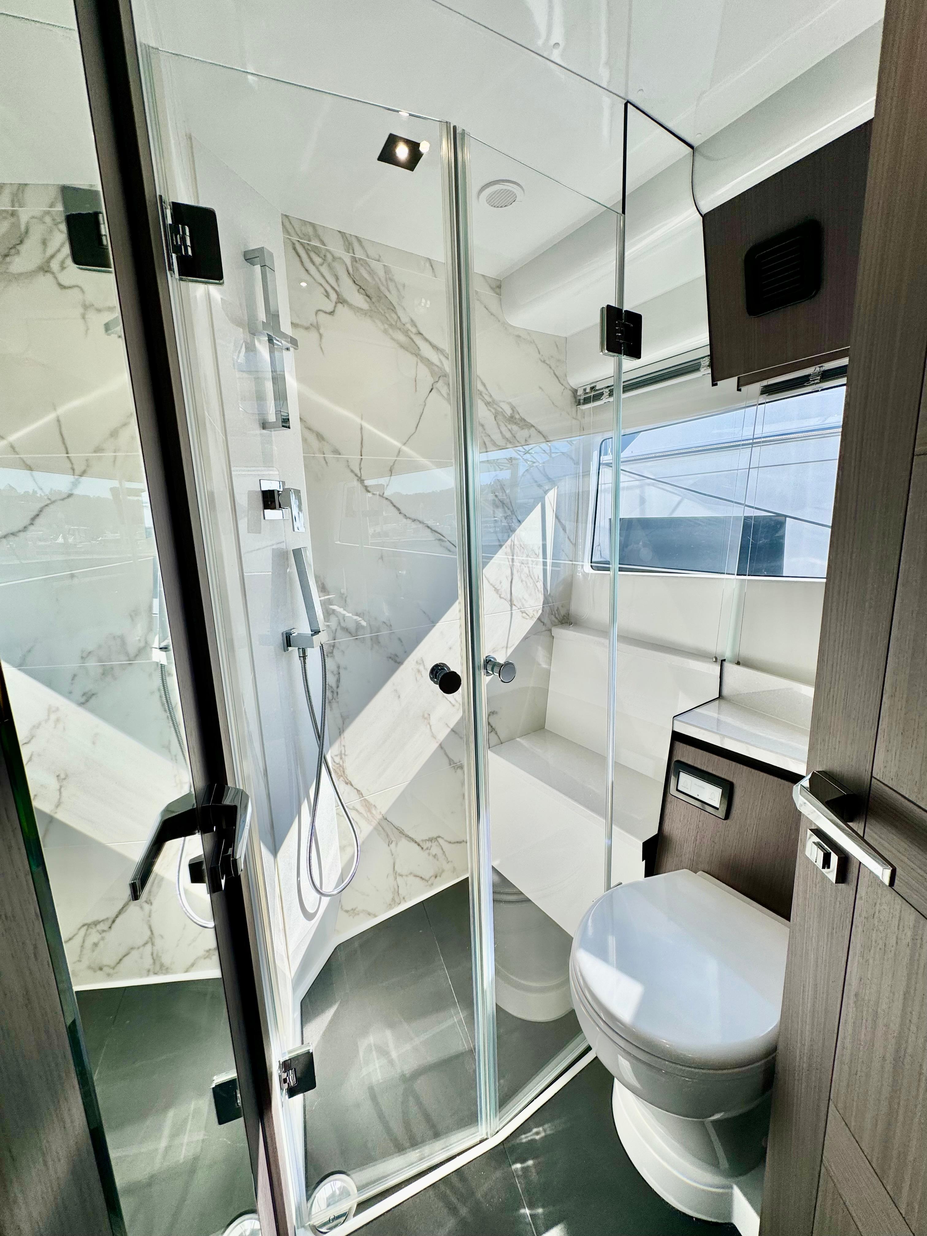 Luxurious bathroom in 2025 Galeon 500 Fly yacht with modern fixtures and glass shower.
