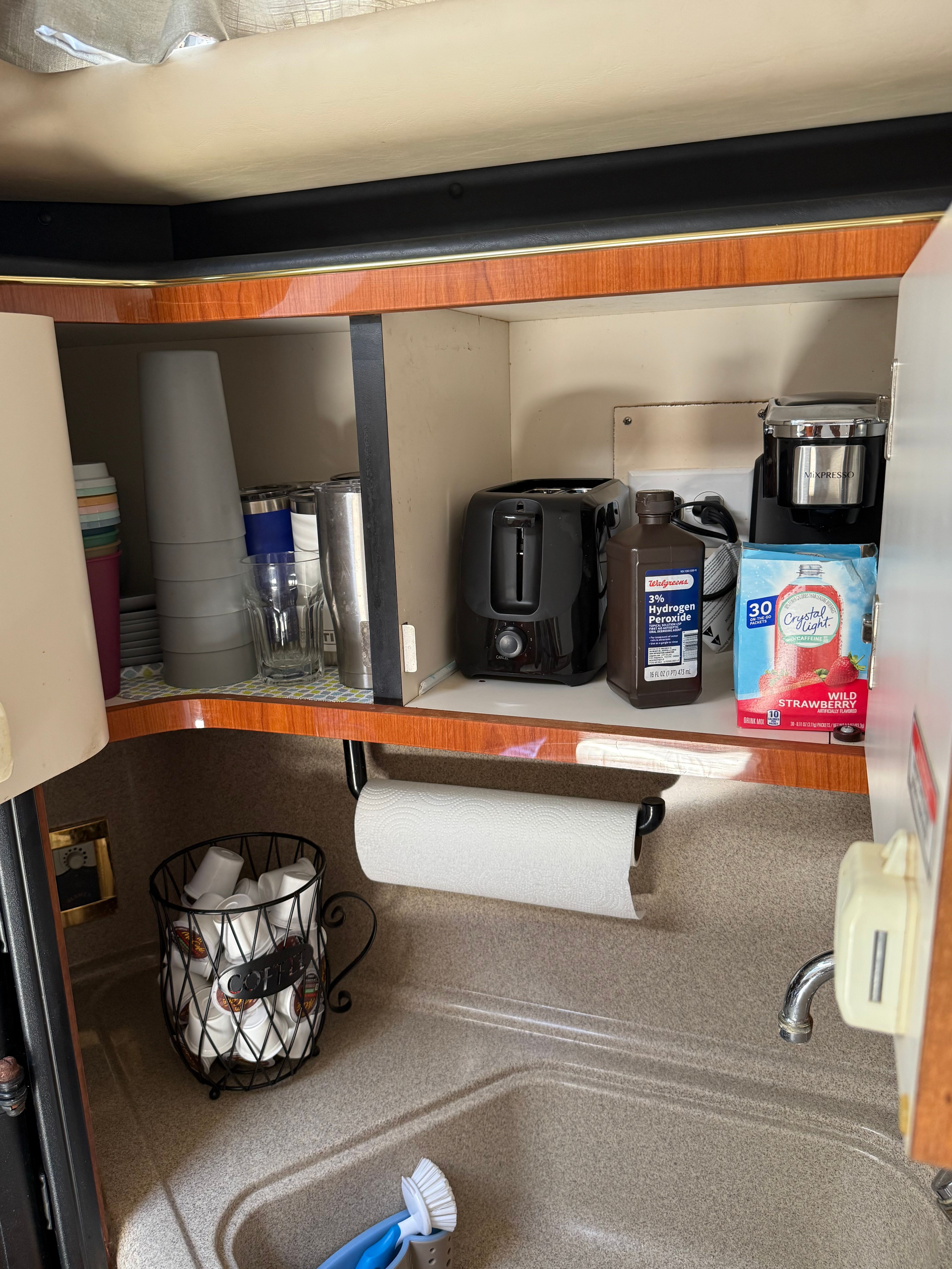Kitchen area of a Sea Ray 380 Sundancer with coffee maker and dishes.