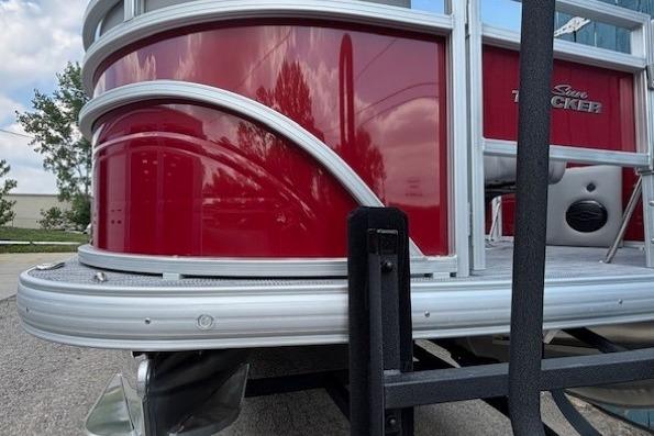 2026 Sun Tracker SportFish 20 DLX pontoon boat, red exterior, docked outdoors.