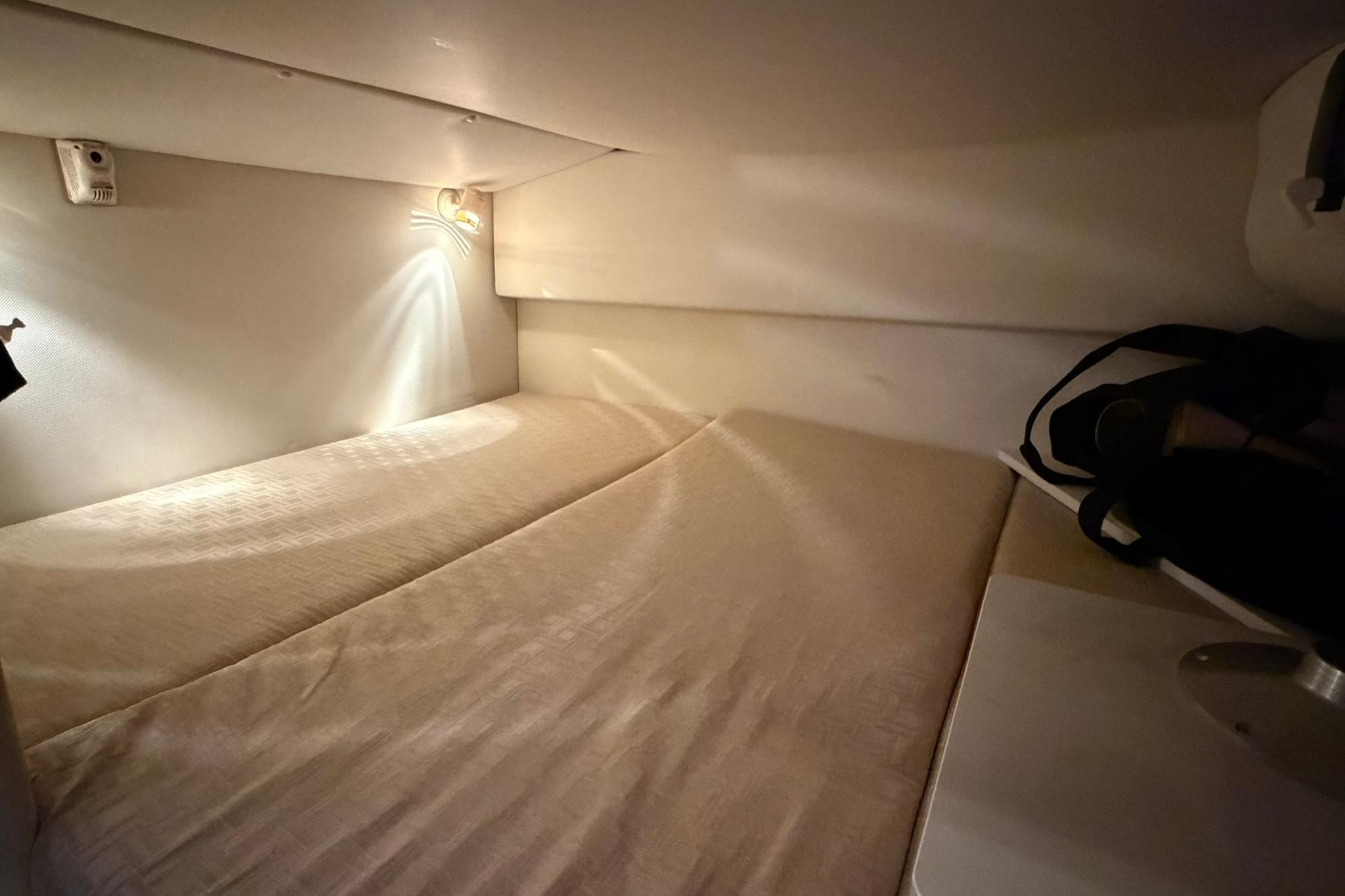 Cozy cabin interior of 2008 Four Winns V248 boat with soft lighting and comfortable bedding.