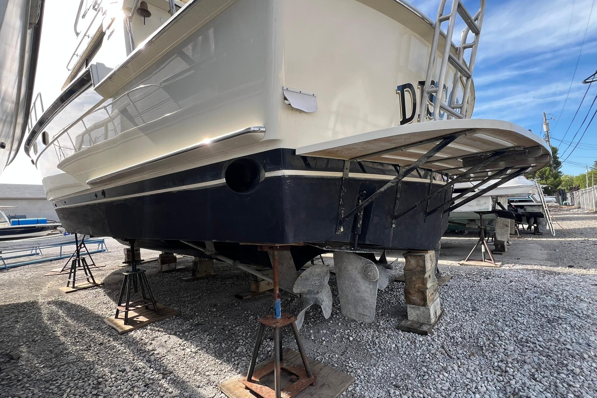 1990 Hatteras 41 Convertible boat on stands, showcasing hull and propellers.