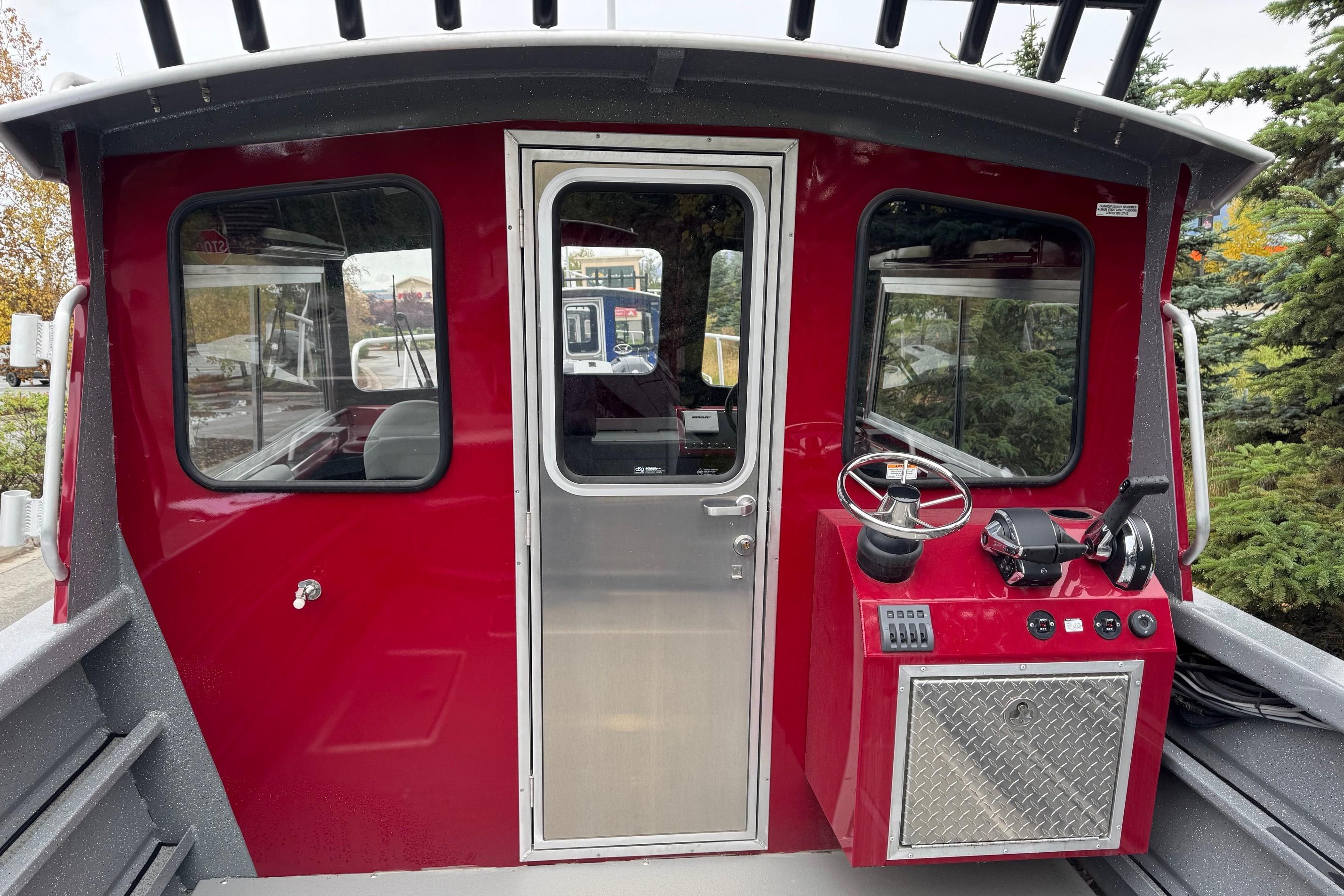 Red cabin of 2024 Spartan 24 MAXIMUS PRO XL boat with steering controls.