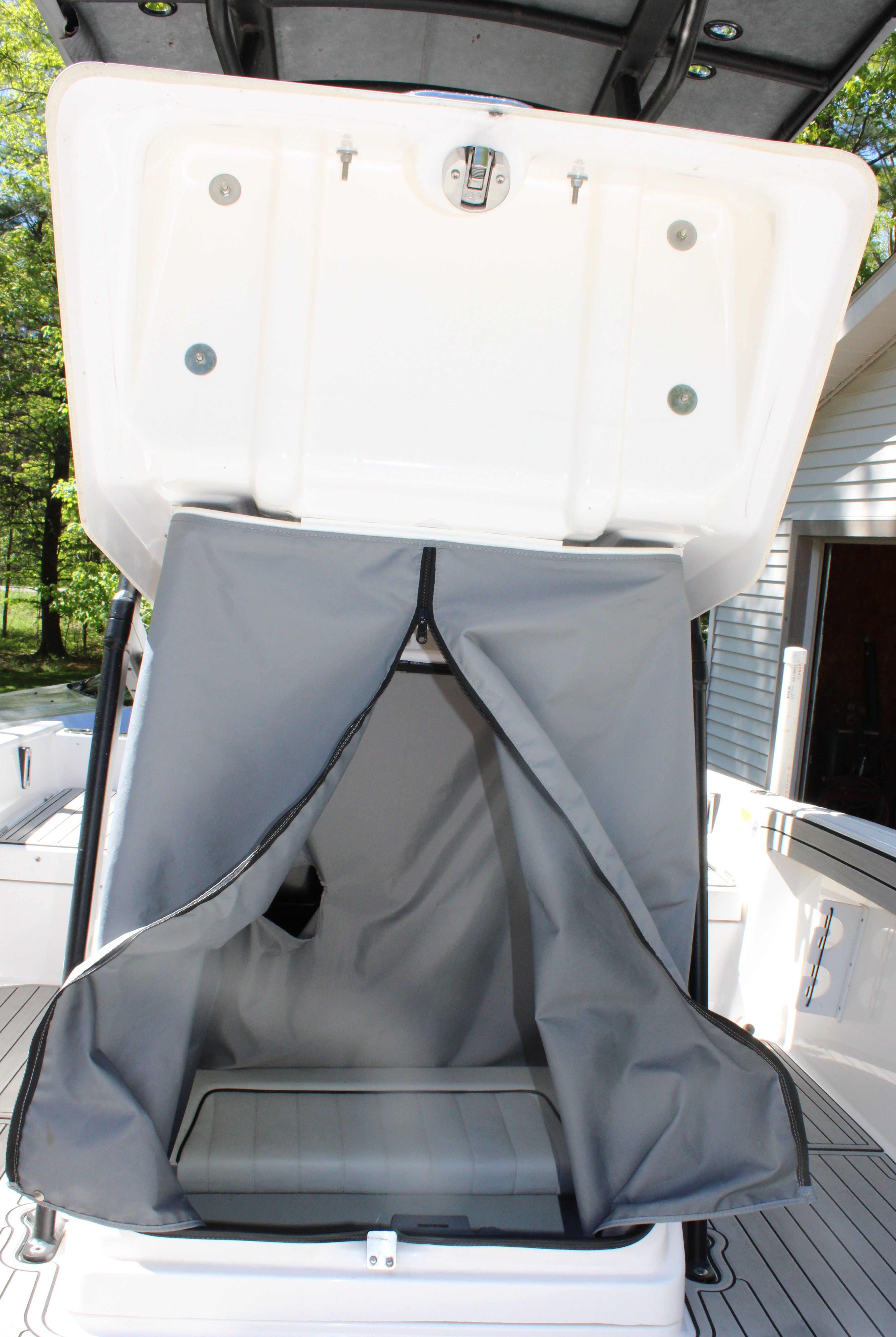 An open storage compartment with a gray curtain on a boat.