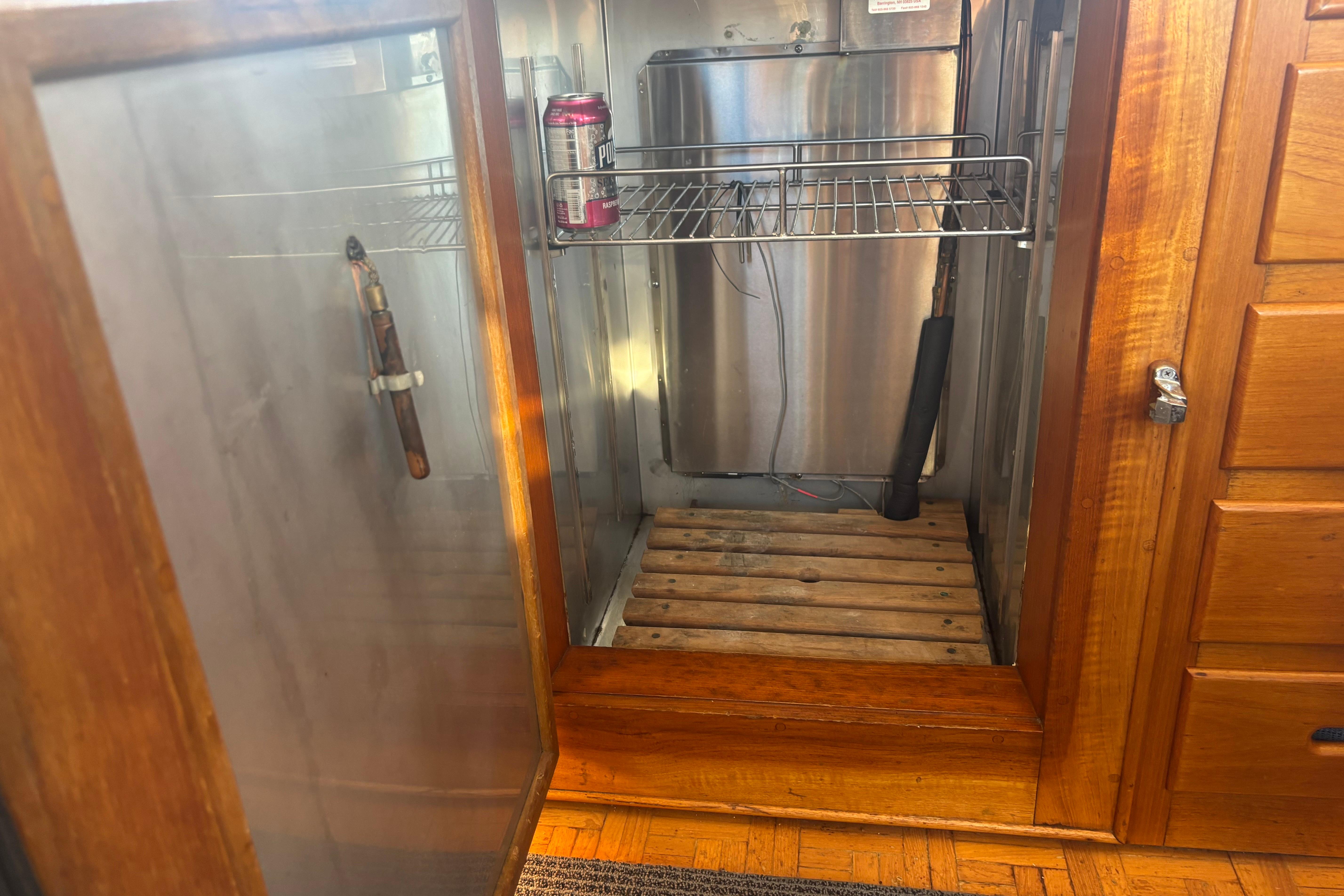 Open wooden cabinet on 1989 Grand Banks 46 Classic yacht, showing interior storage space.