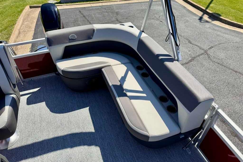 2026 Sun Tracker Bass Buggy 16 XL Select pontoon boat with cushioned seating and cup holders.
