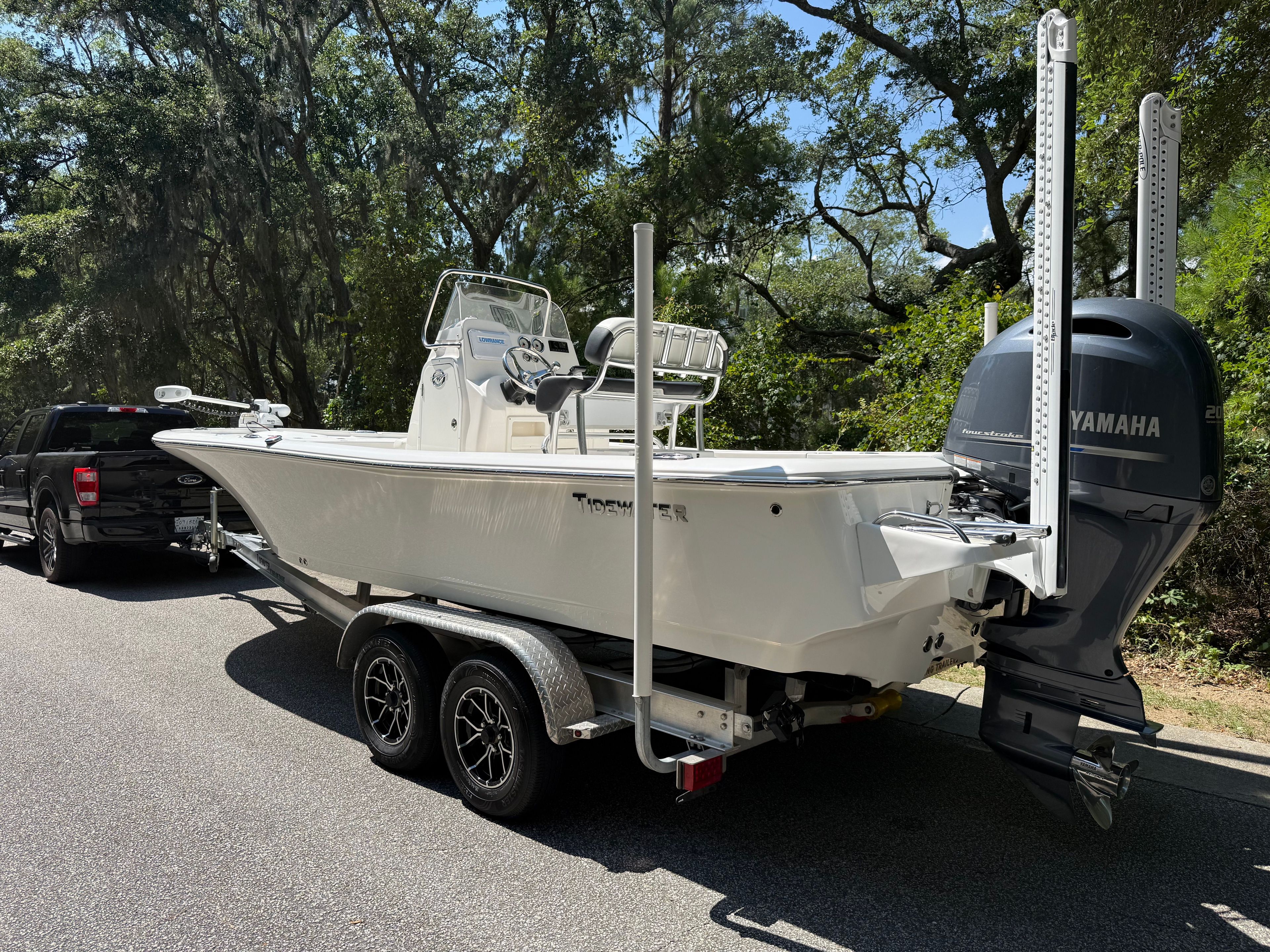 A 2023 Tidewater 2210 Carolina Bay on a trailer, towed by a black vehicle.