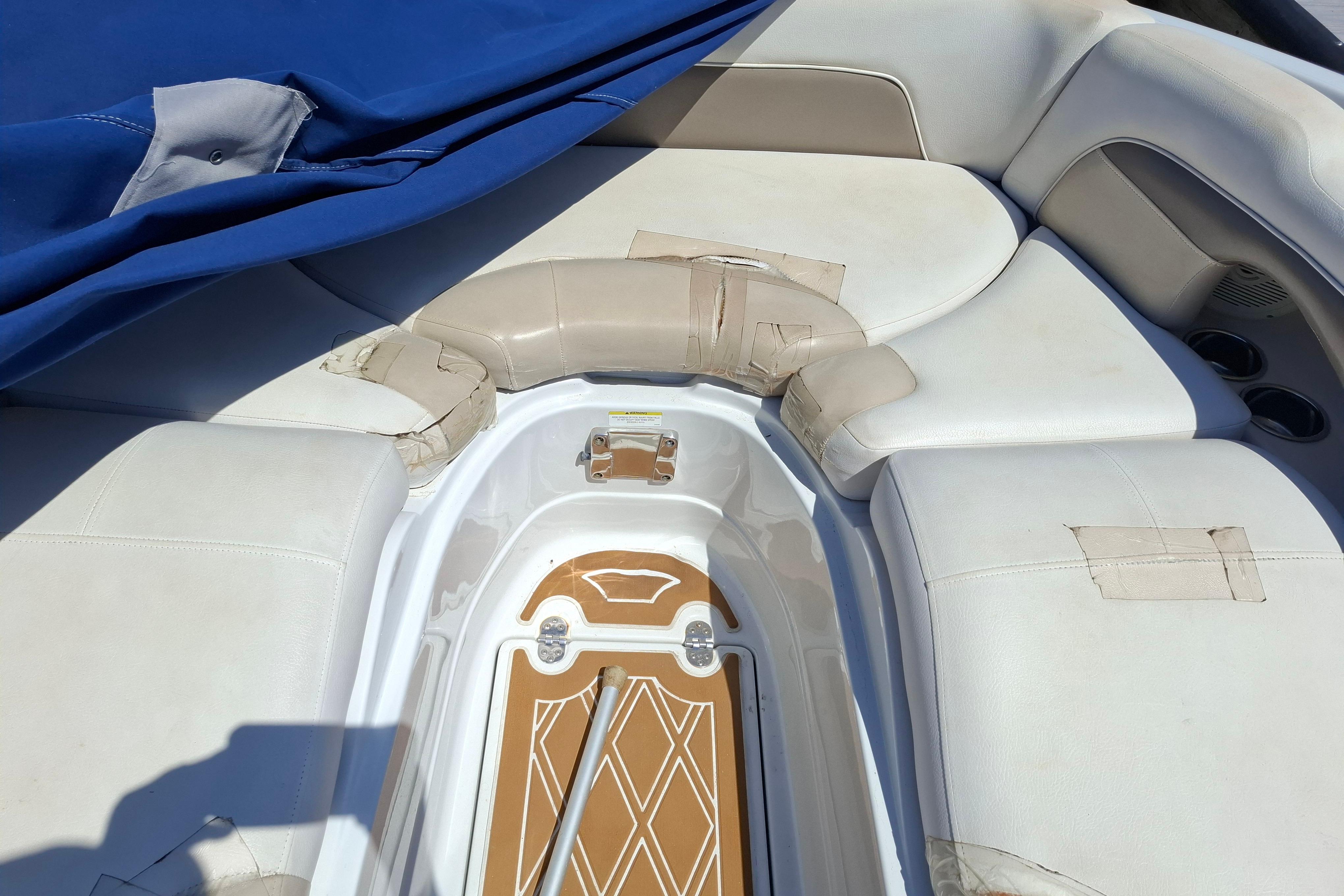 Interior of a 2013 Crownline Eclipse E6 boat with white seating and blue cover.