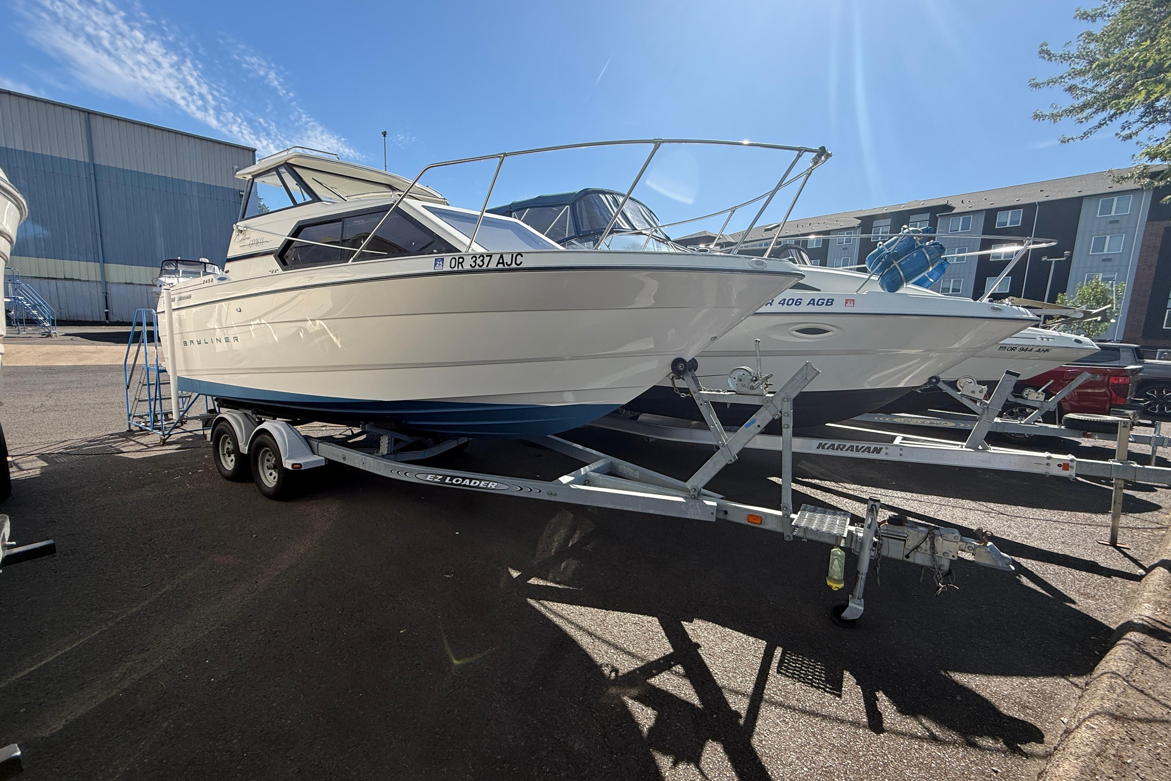 1997 Bayliner 2452 Ciera Express boat on trailer in sunny marina.