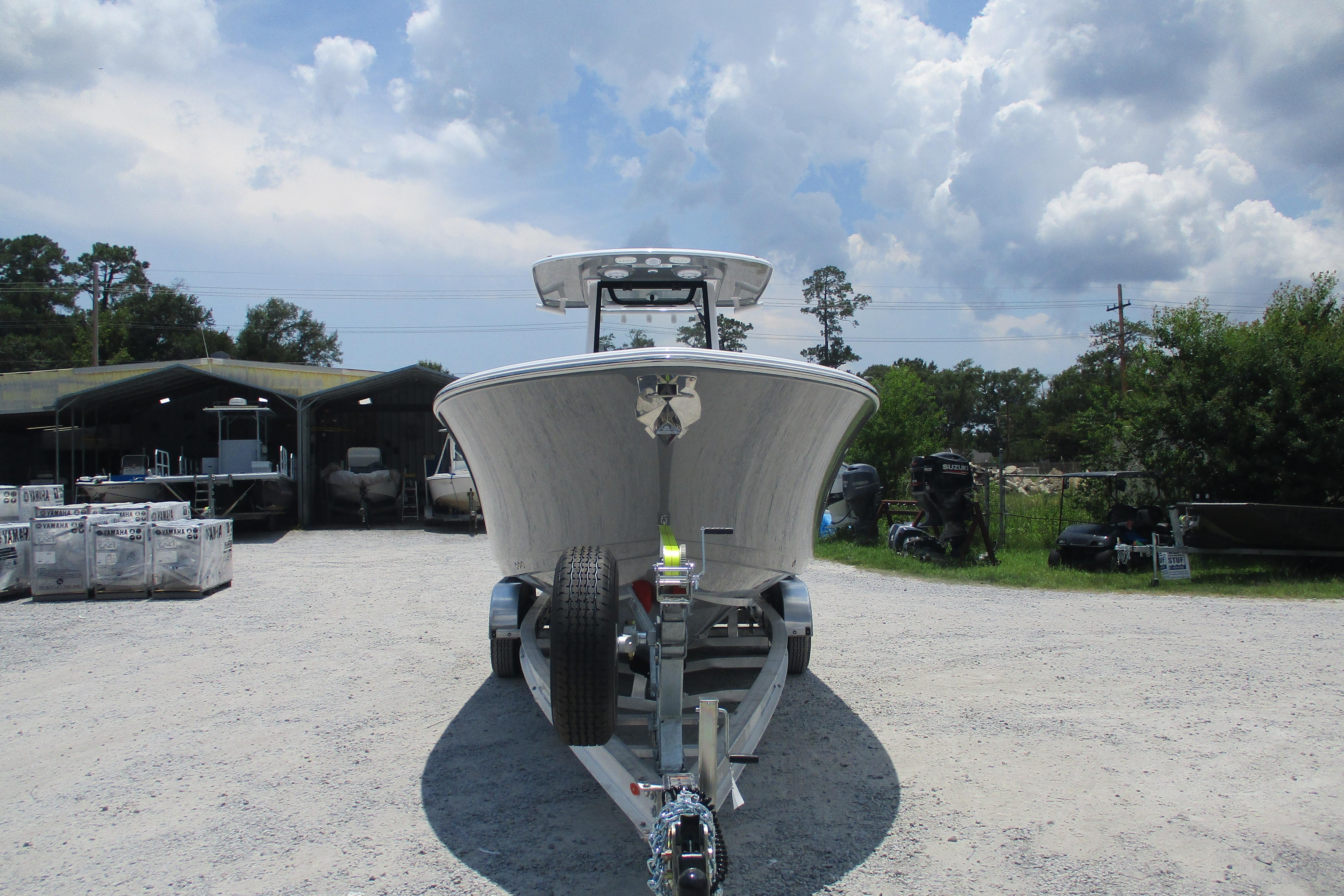 2027 Sportsman Open 252 Center Console boat on trailer under cloudy sky.