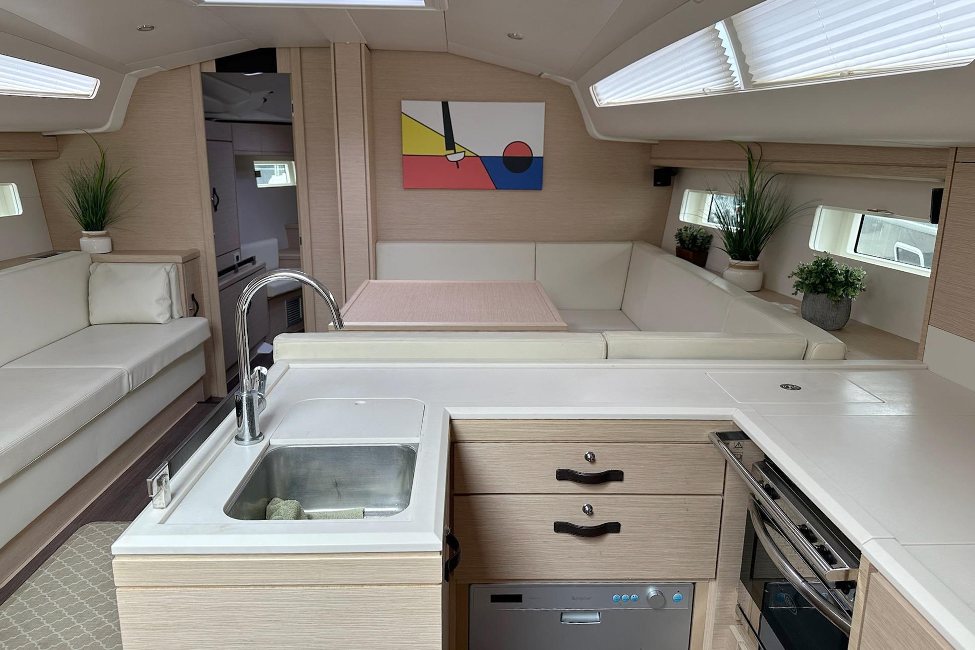 Luxurious interior of a 2018 Jeanneau 51 yacht with modern kitchen and seating area.