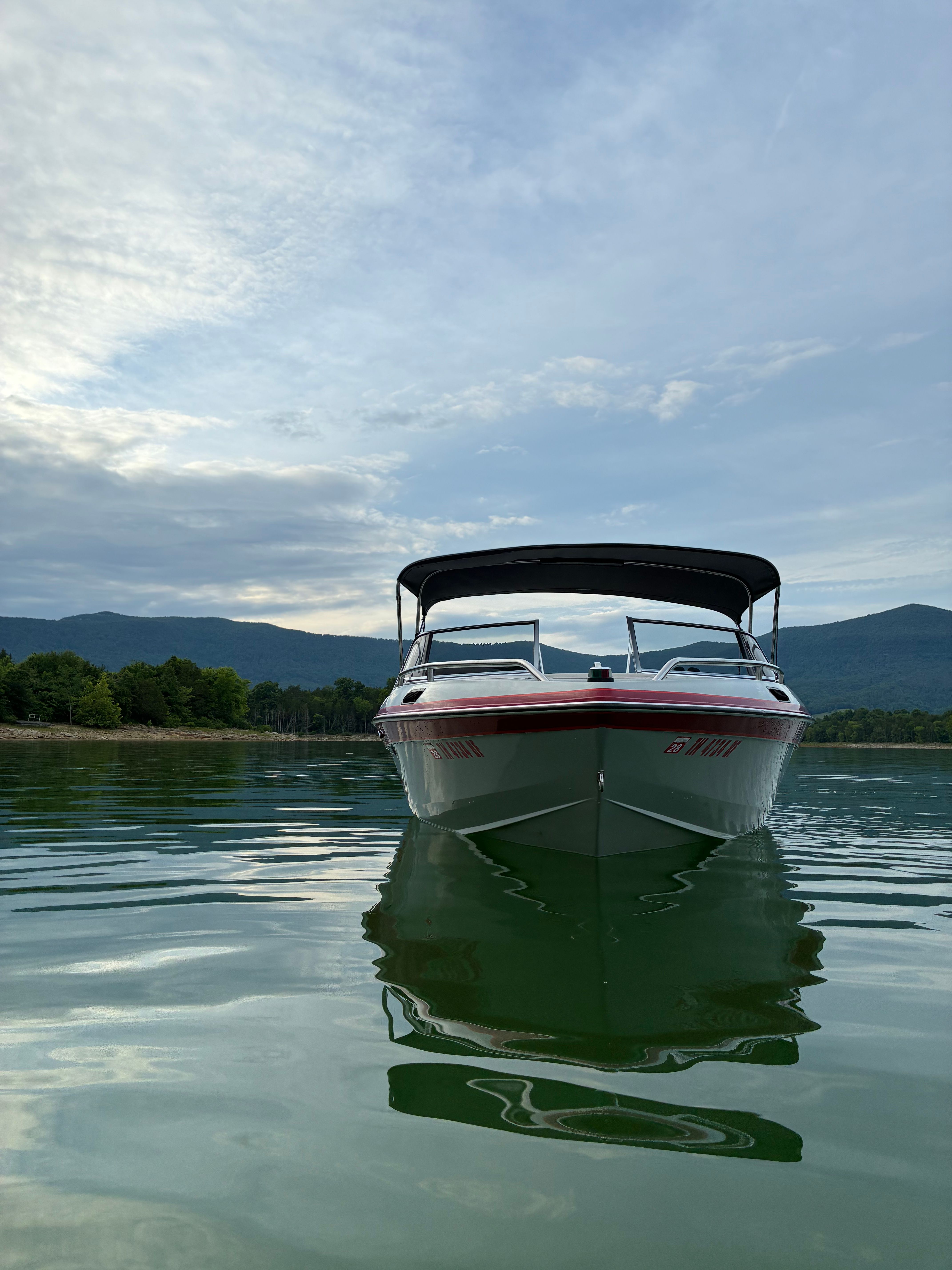 A 1989 MasterCraft TriStar 190 on calm water with wooded hills in the background.
