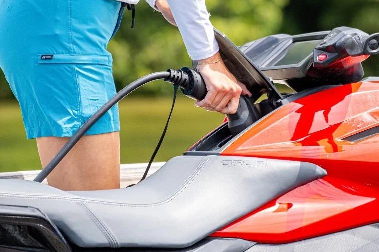 Charging a 2025 Taiga Orca P2 electric watercraft in a scenic outdoor setting.
