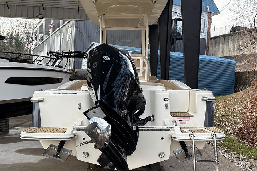 2024 Scout 215 XSF boat with powerful outboard motor, docked under shelter.