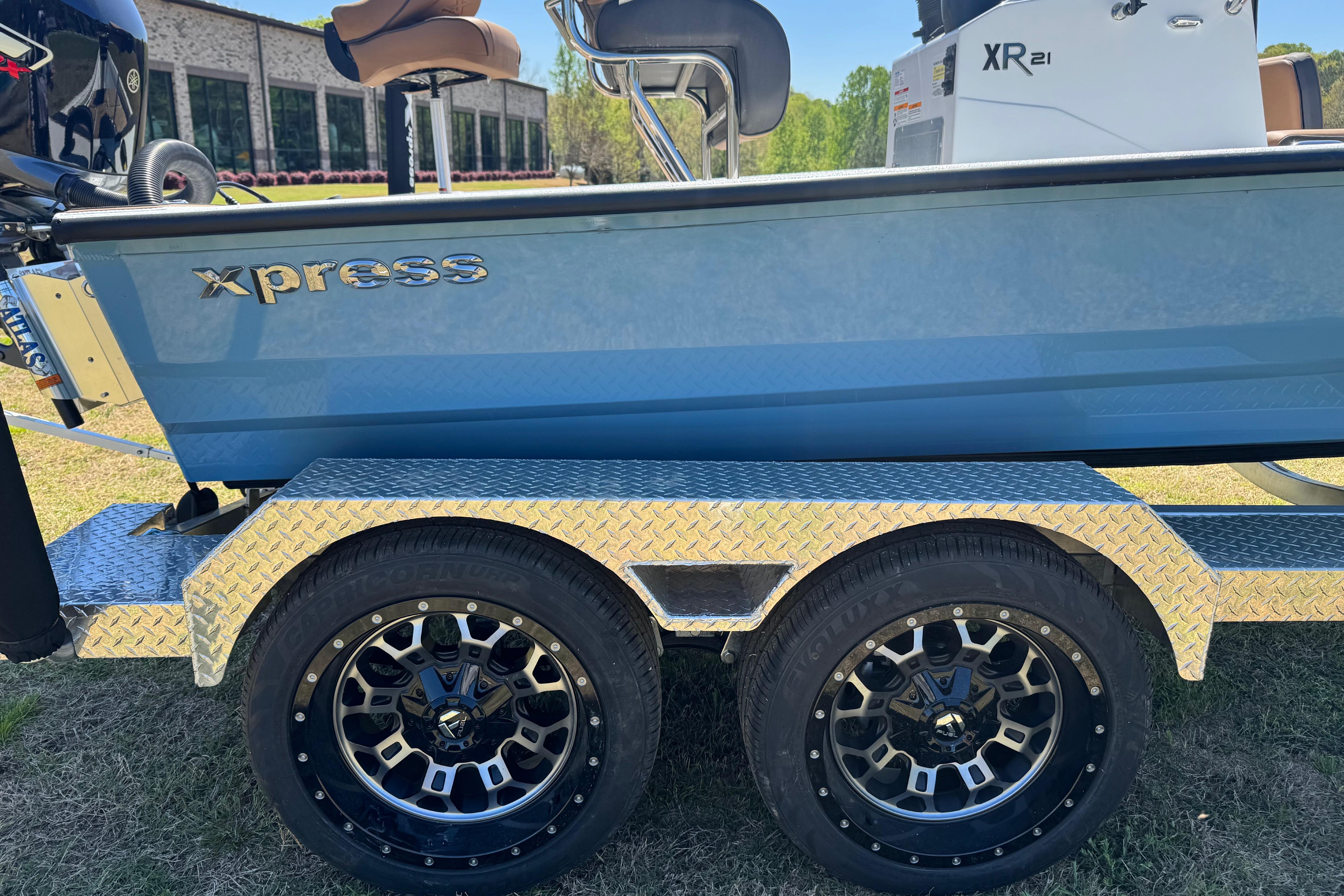 2026 Xpress XR21 Bay boat on a trailer with stylish wheels.