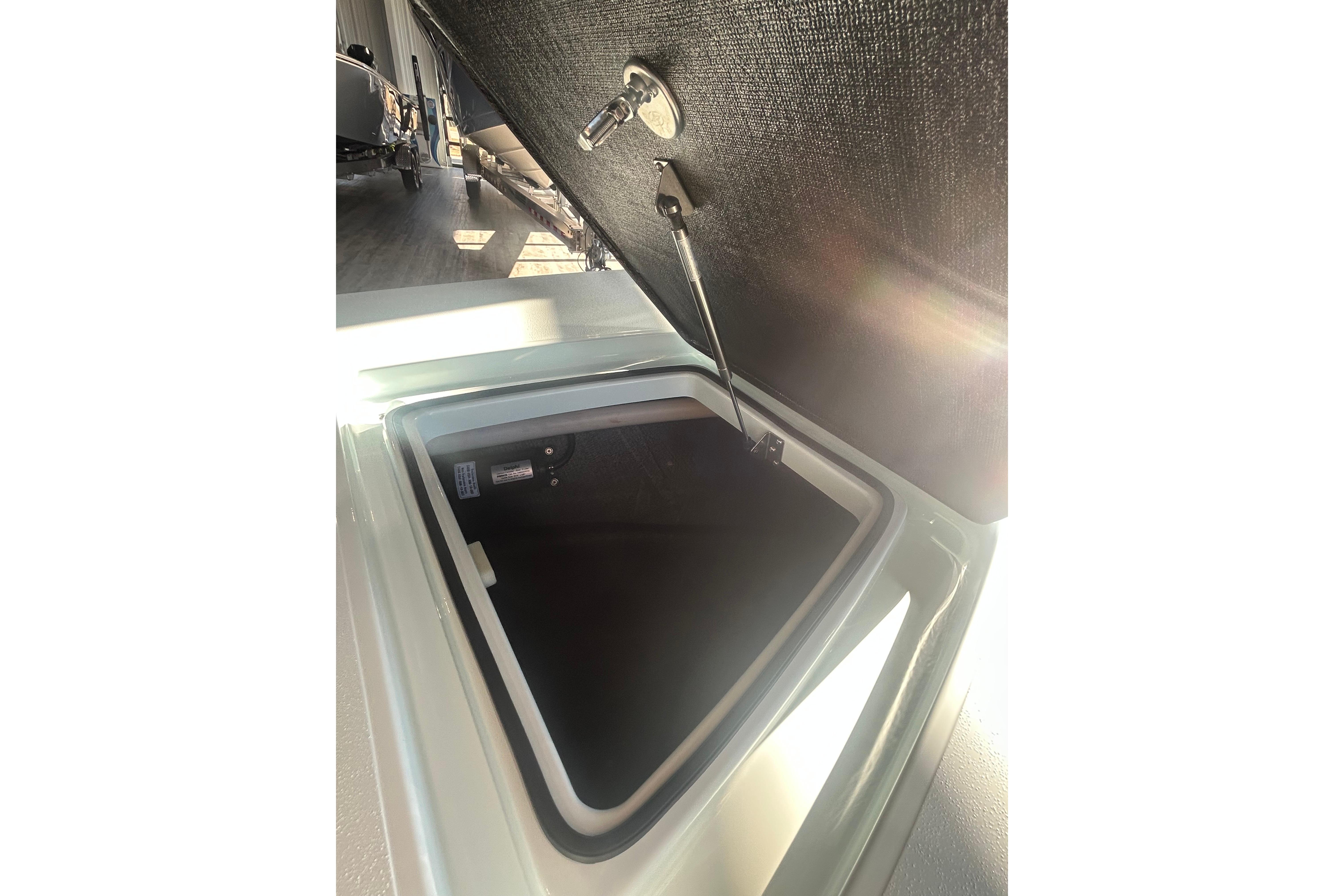 Open storage compartment of 2026 East Cape Evo 17X boat, showcasing interior details.