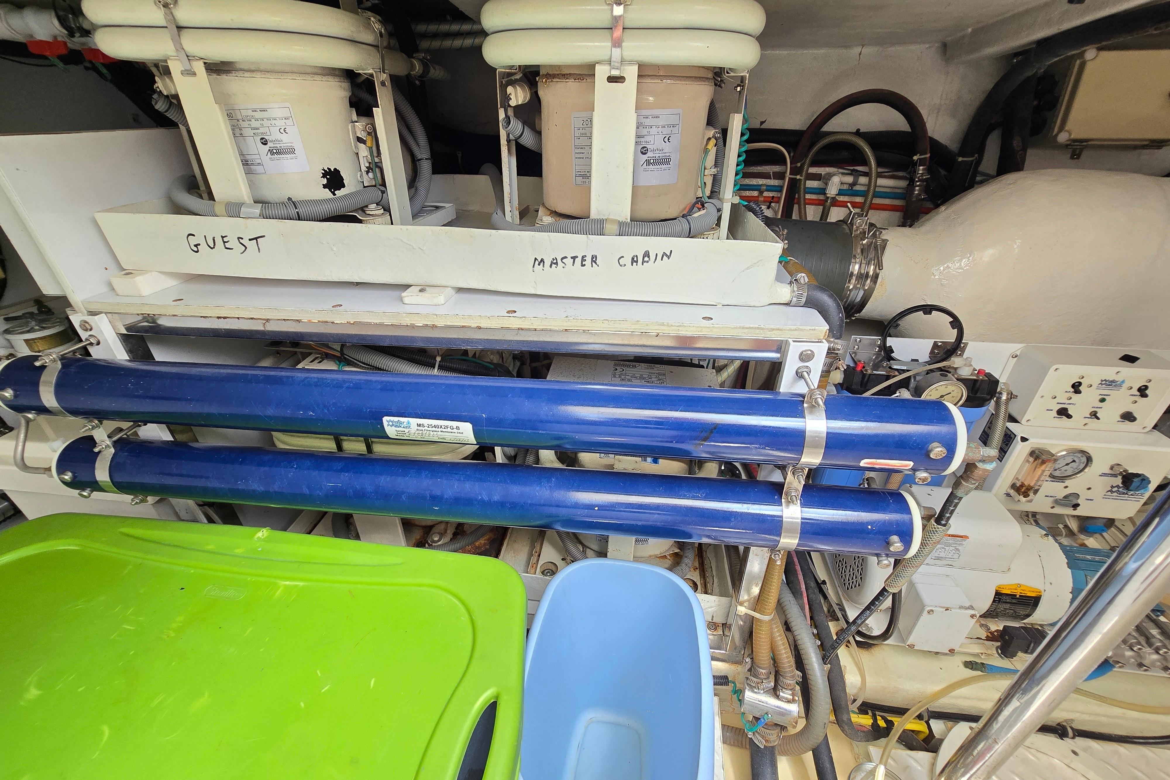 Engine room of a 2004 Grand Harbour 58 yacht, featuring labeled equipment and piping.