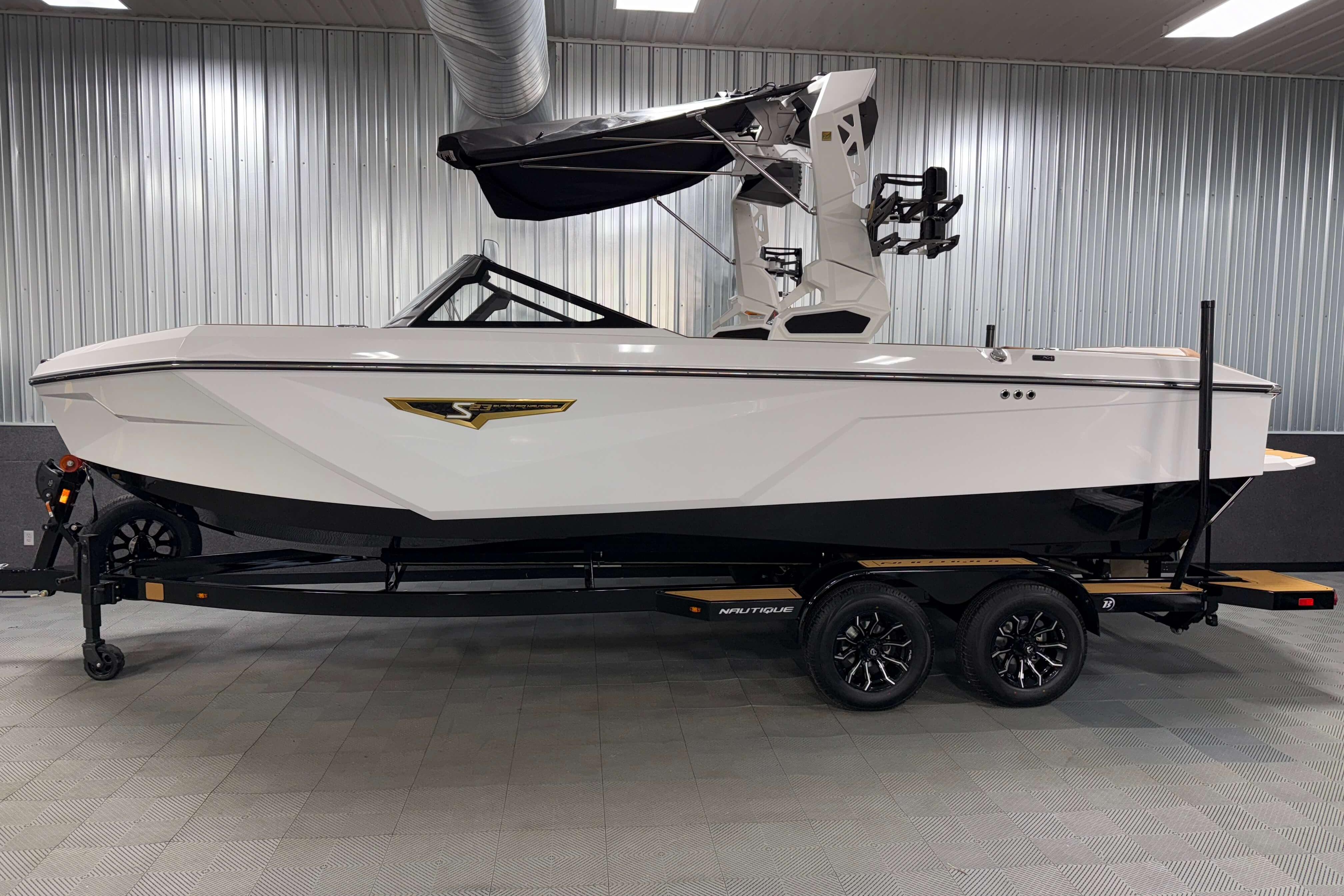 2026 Nautique Super Air Nautique S23 boat in showroom, side view.