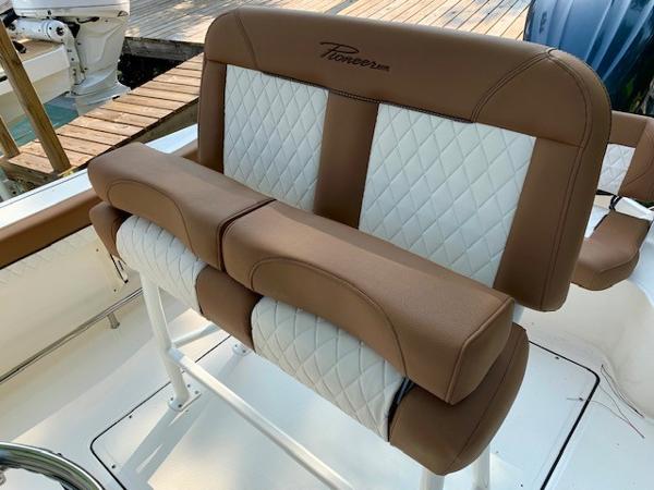 2025 Pioneer 222 Islander boat seating with brown and white quilted upholstery.