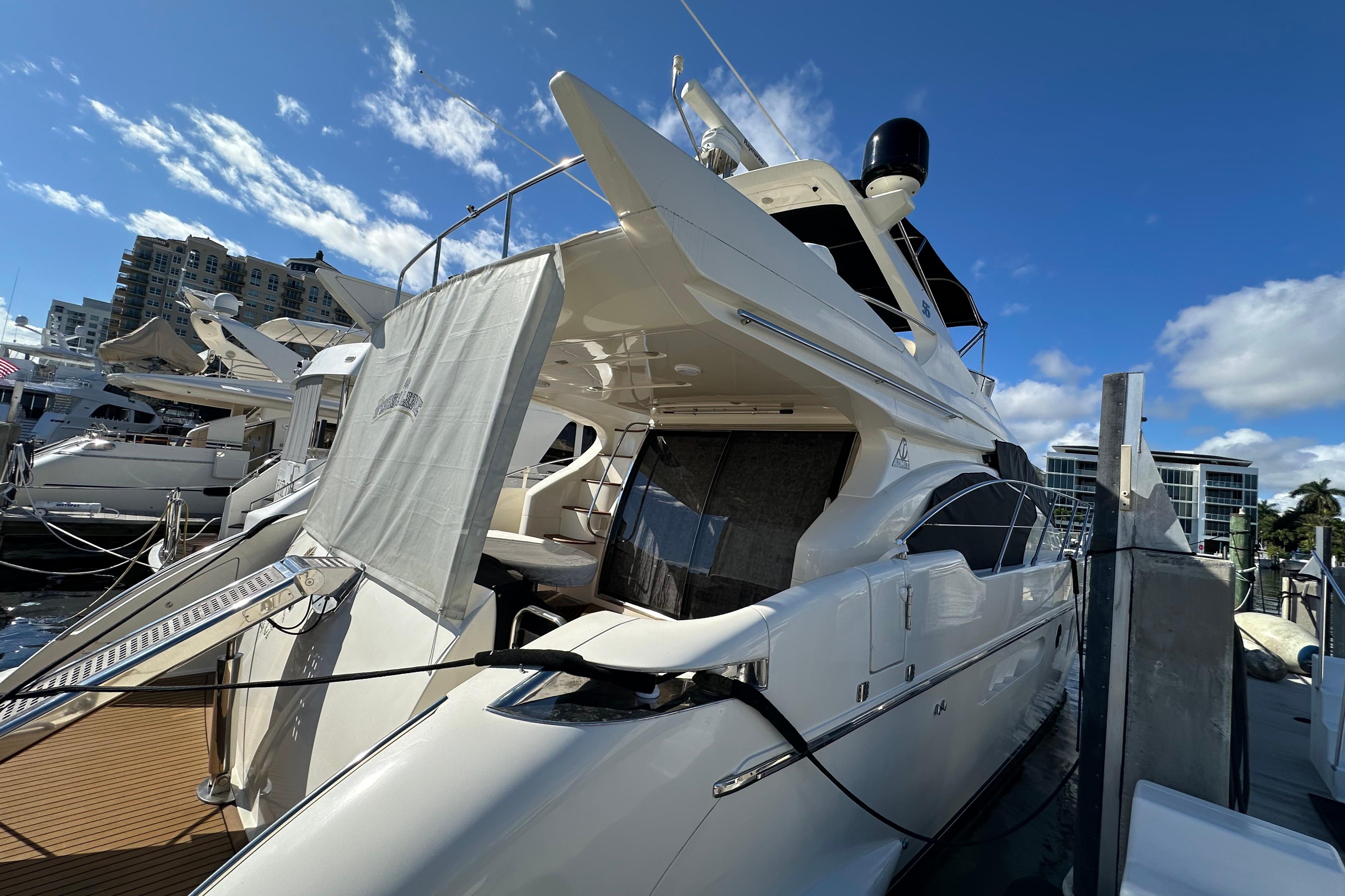 Luxury 2004 Azimut 55E yacht docked under a clear blue sky.