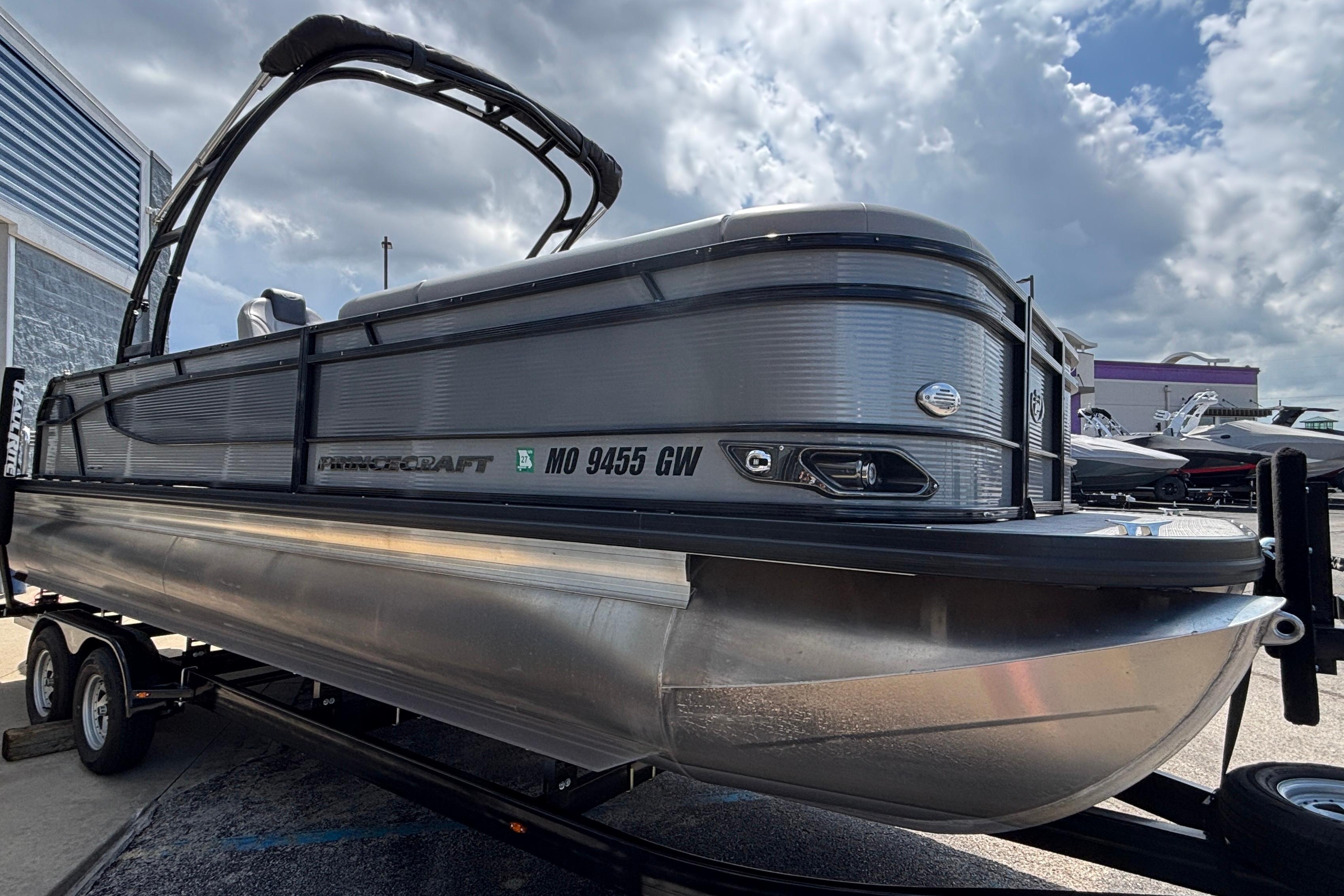 2023 Princecraft Quorum 25 RL pontoon boat on trailer under cloudy sky.
