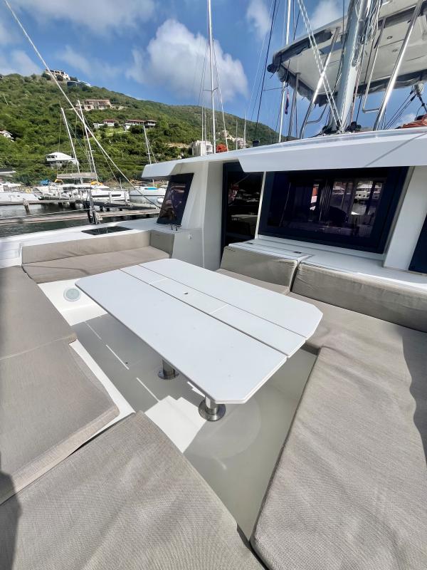 2023 Bali 4.6 yacht with outdoor seating, docked in a scenic marina.