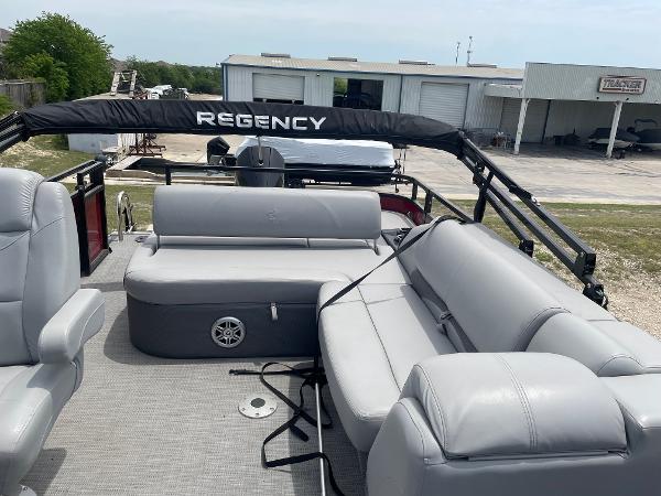 2023 Regency 250DL3 pontoon boat with gray seating and black canopy.