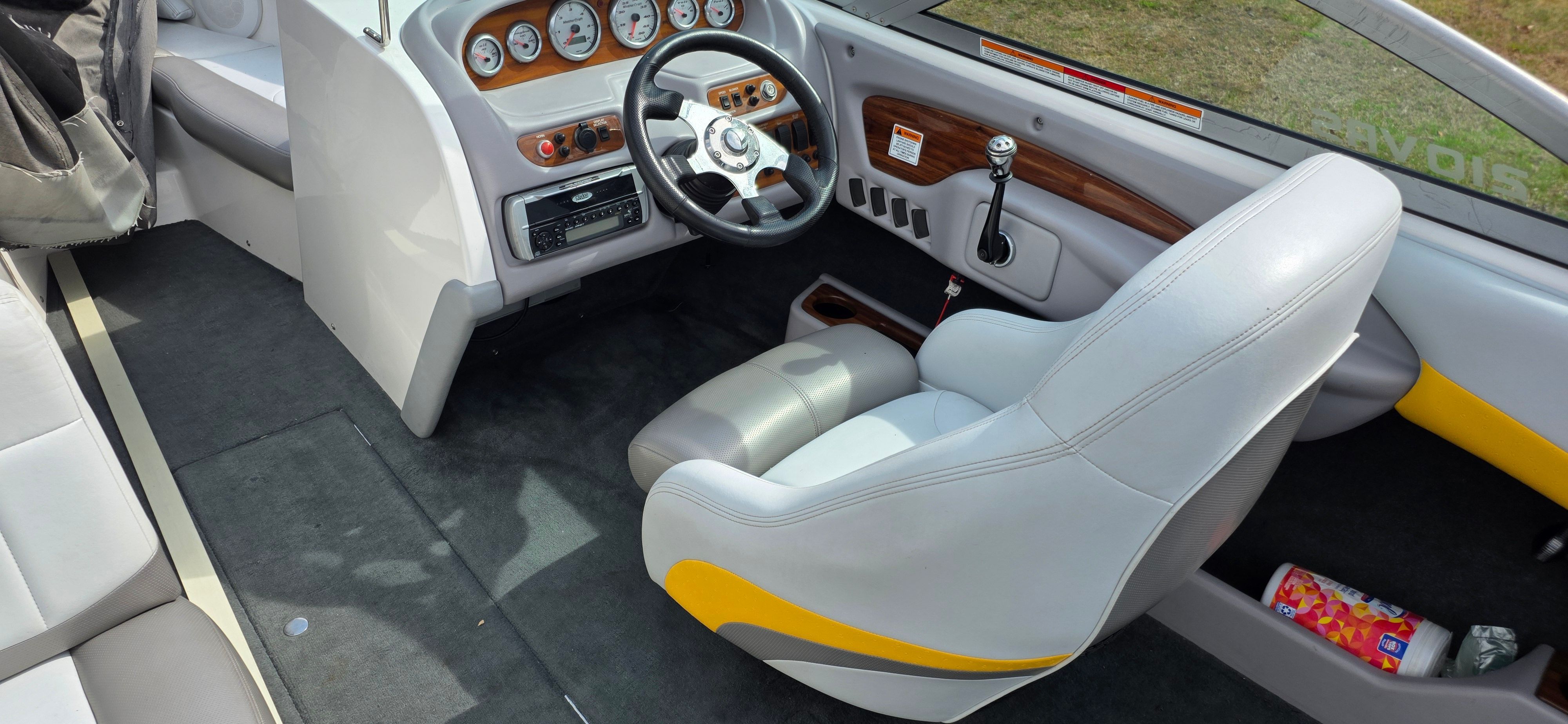 Interior of a 2004 MasterCraft Maristar boat with gray seats and wood accents.