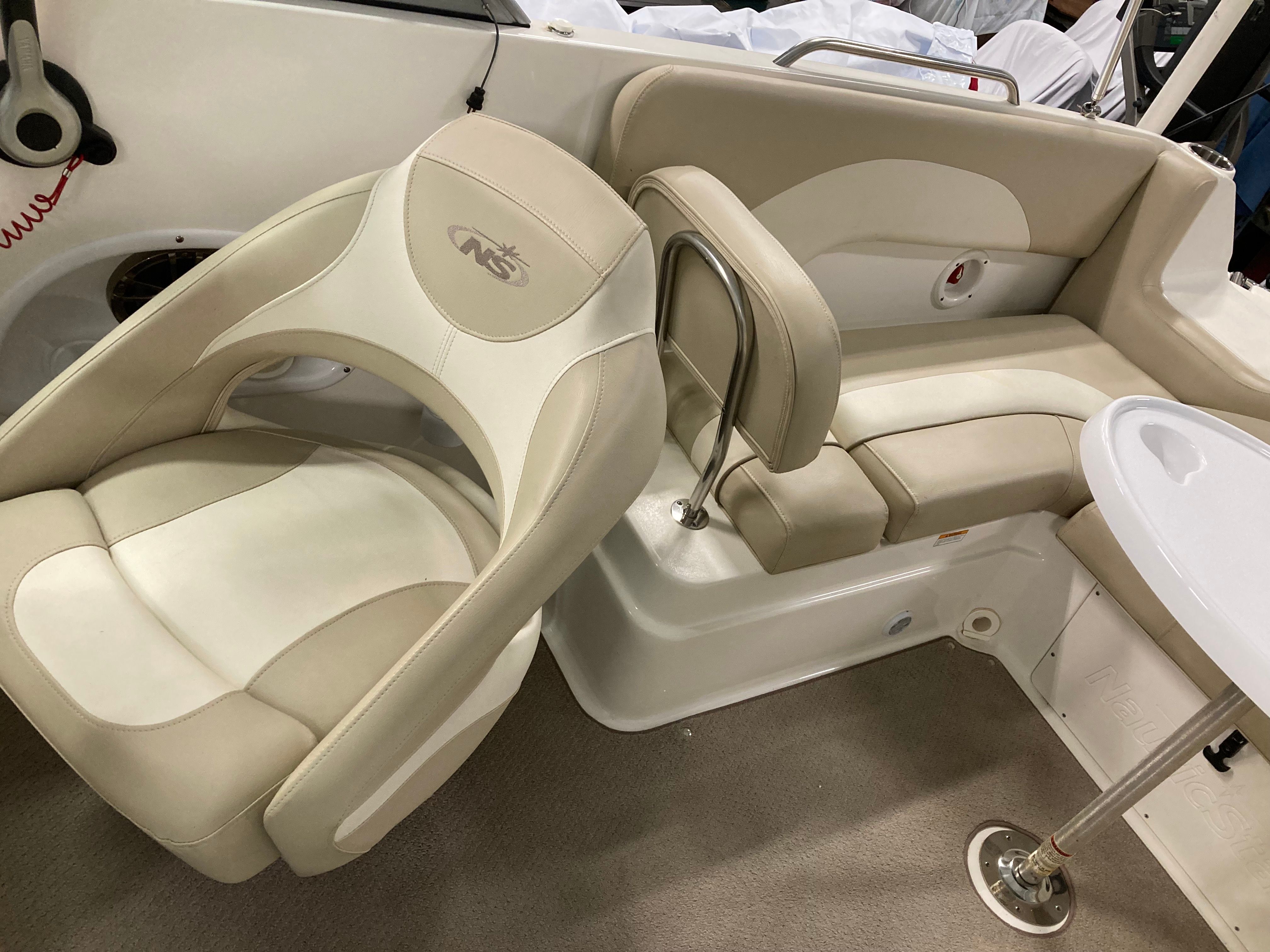 Interior of a 2016 Custom 223 DC boat with beige and white seating.