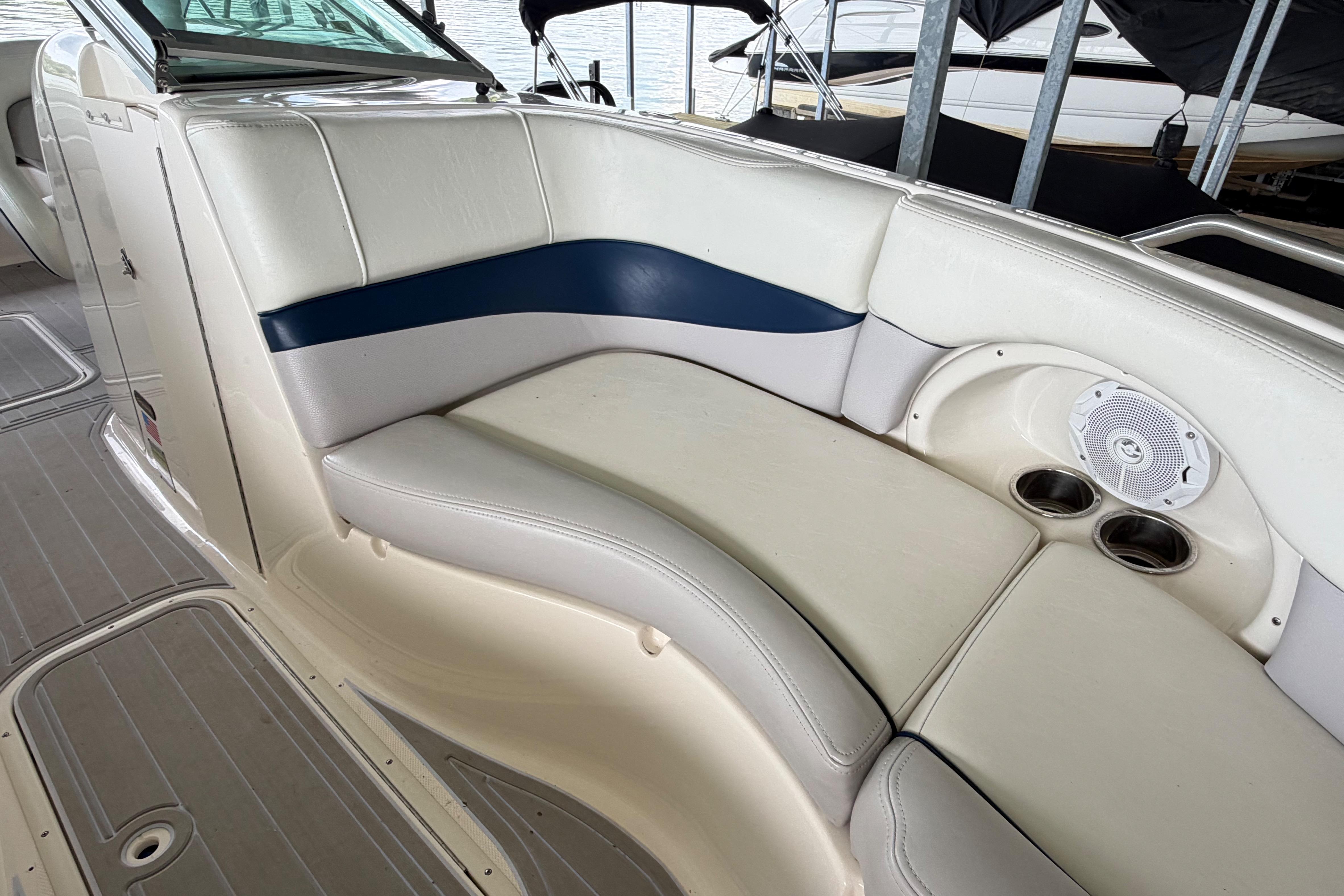 Luxurious seating on a 2010 Bryant 255 boat with cup holders and speaker.