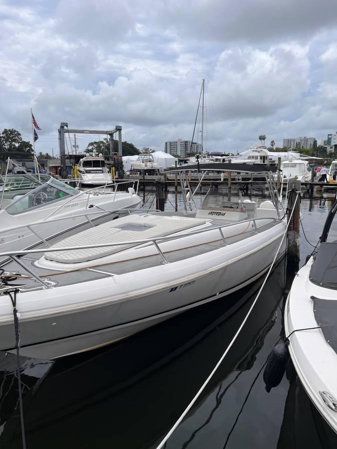 1996 Intrepid 370 Cuddy boat docked at a marina under cloudy skies.