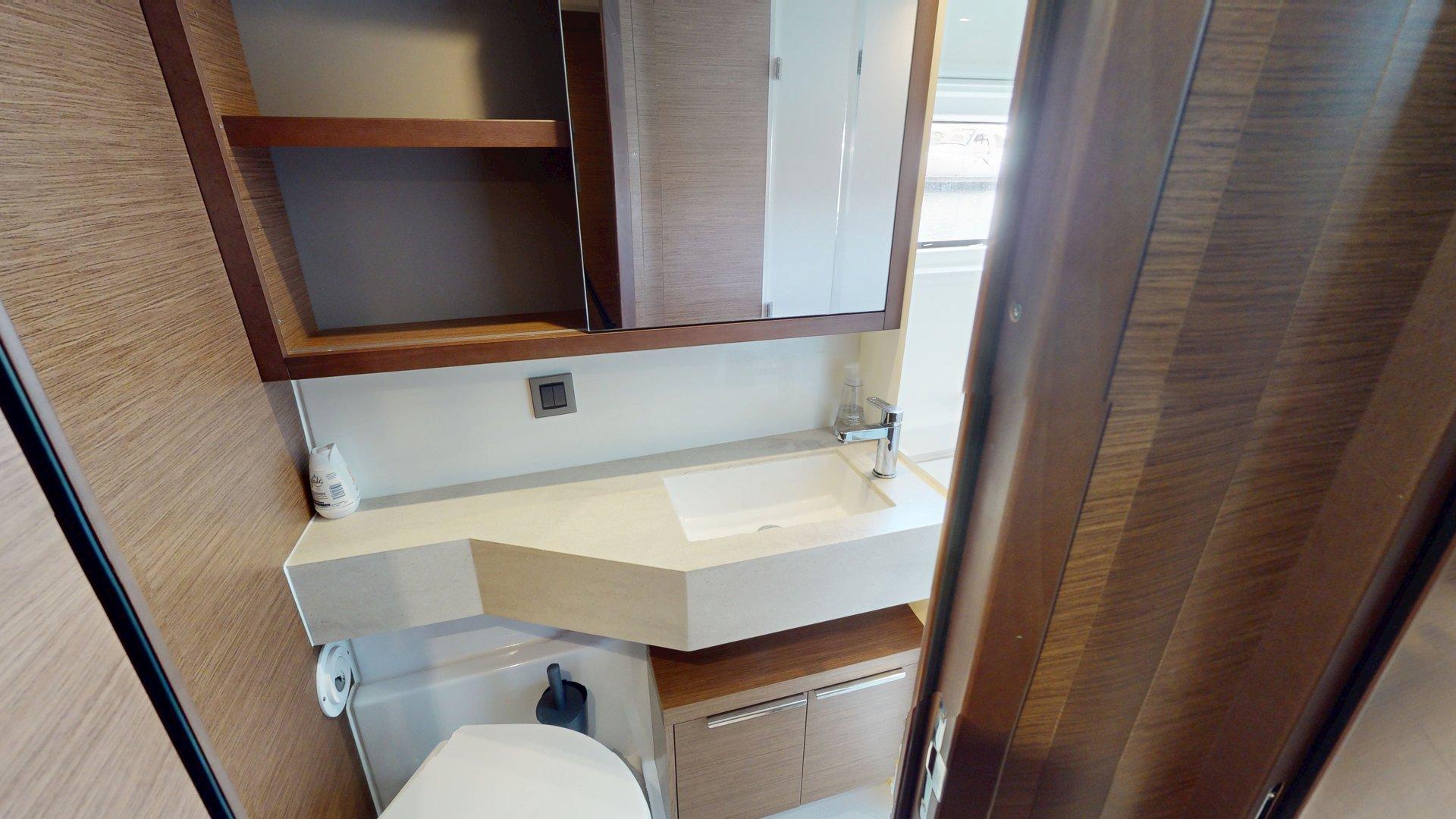 Modern bathroom interior on a 2020 Lagoon 46 yacht, featuring sleek wood finishes and a compact design.