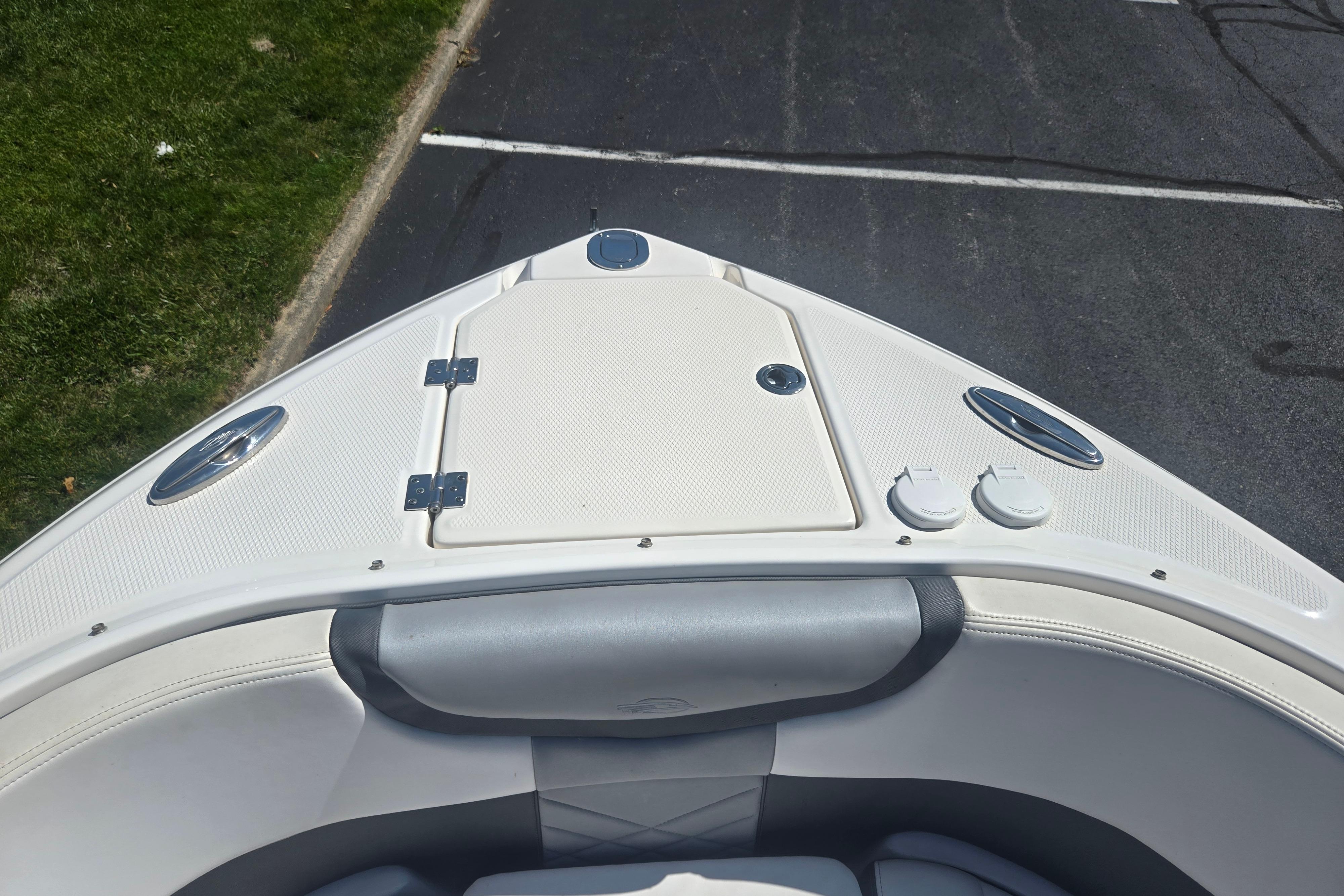 2018 Chaparral 267 SSX boat bow with white seating and storage compartment.