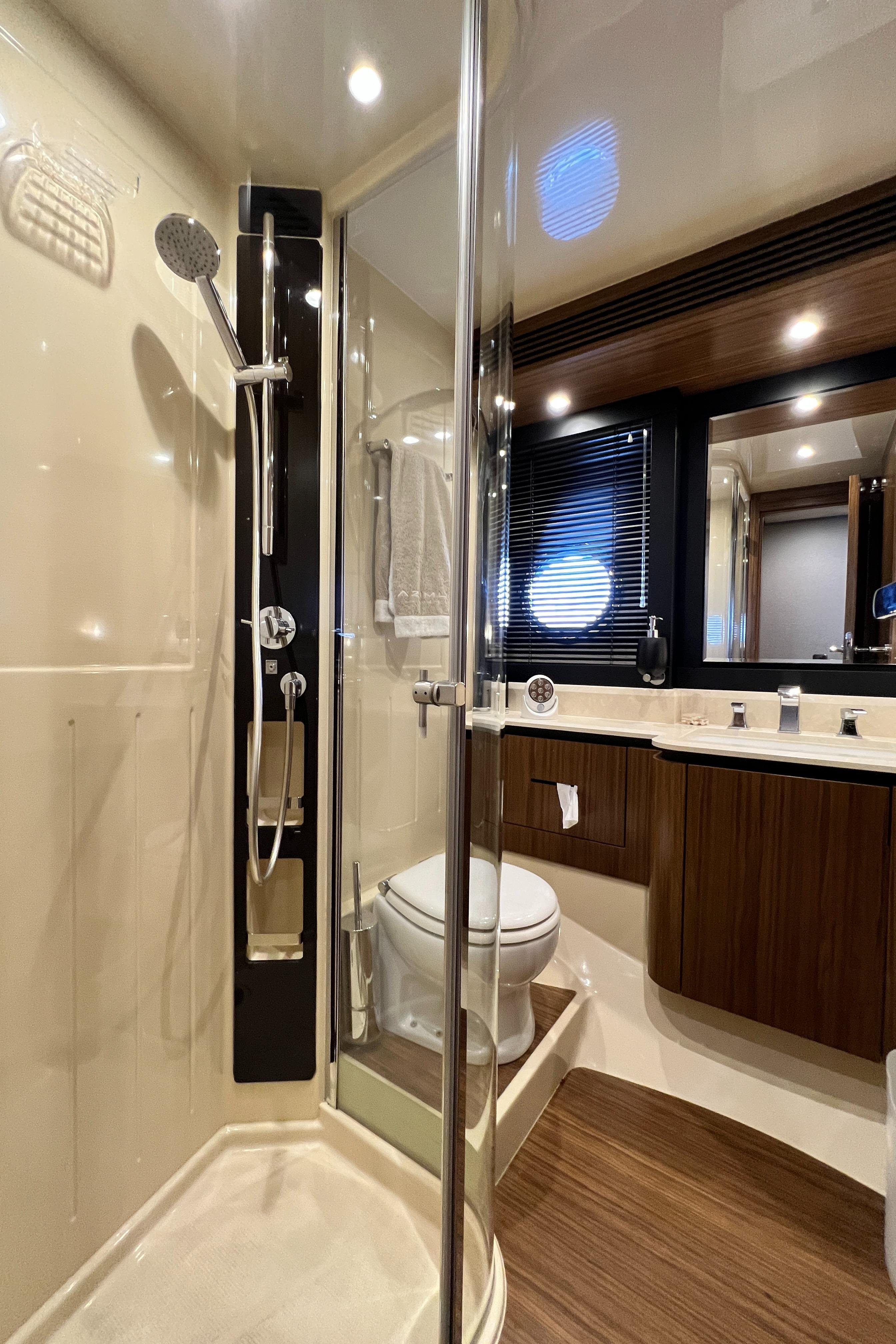2017 Azimut Magellano yacht bathroom with modern shower and wooden cabinetry.