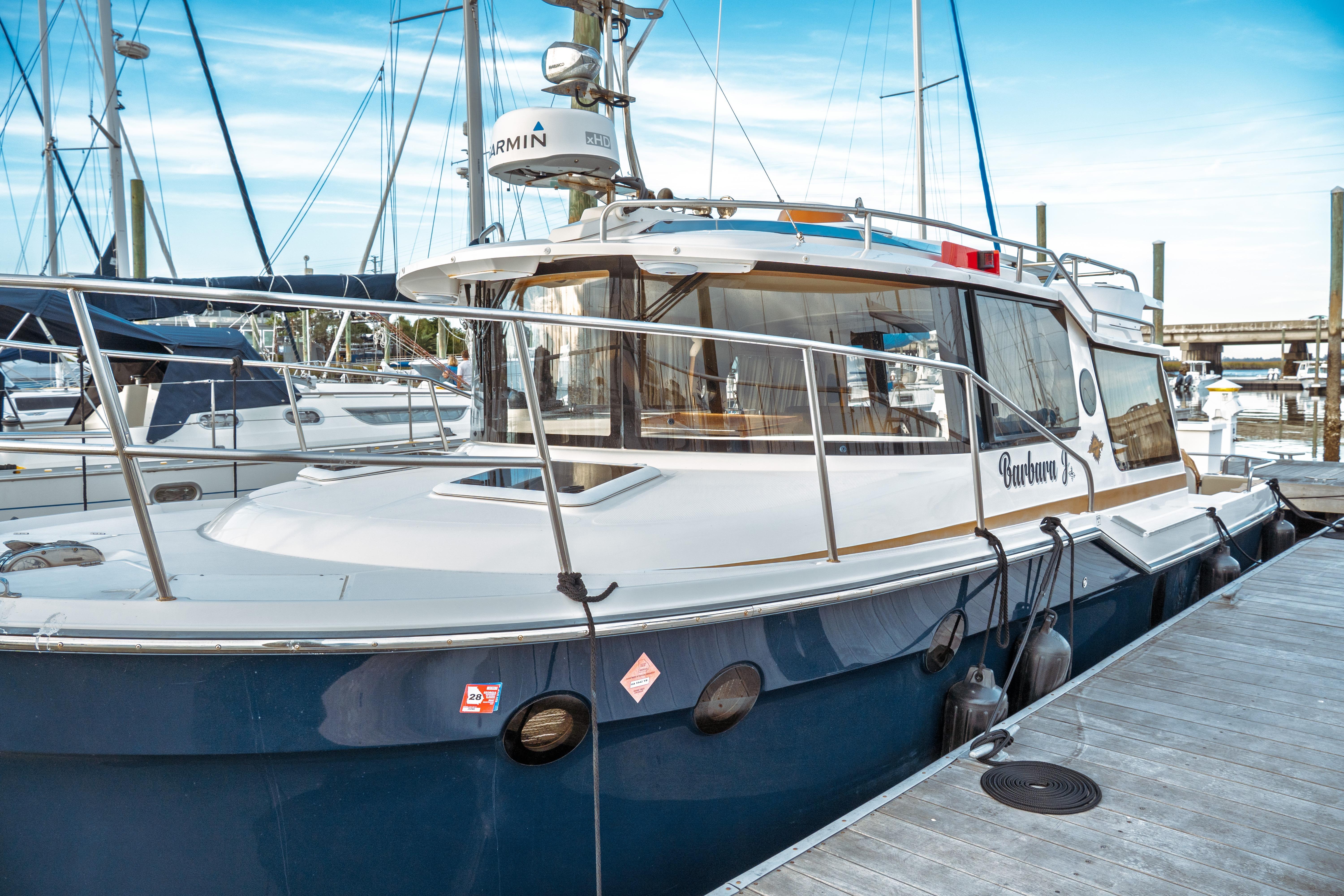 2022 Ranger Tugs R-29 S docked at marina, featuring sleek design and modern amenities.