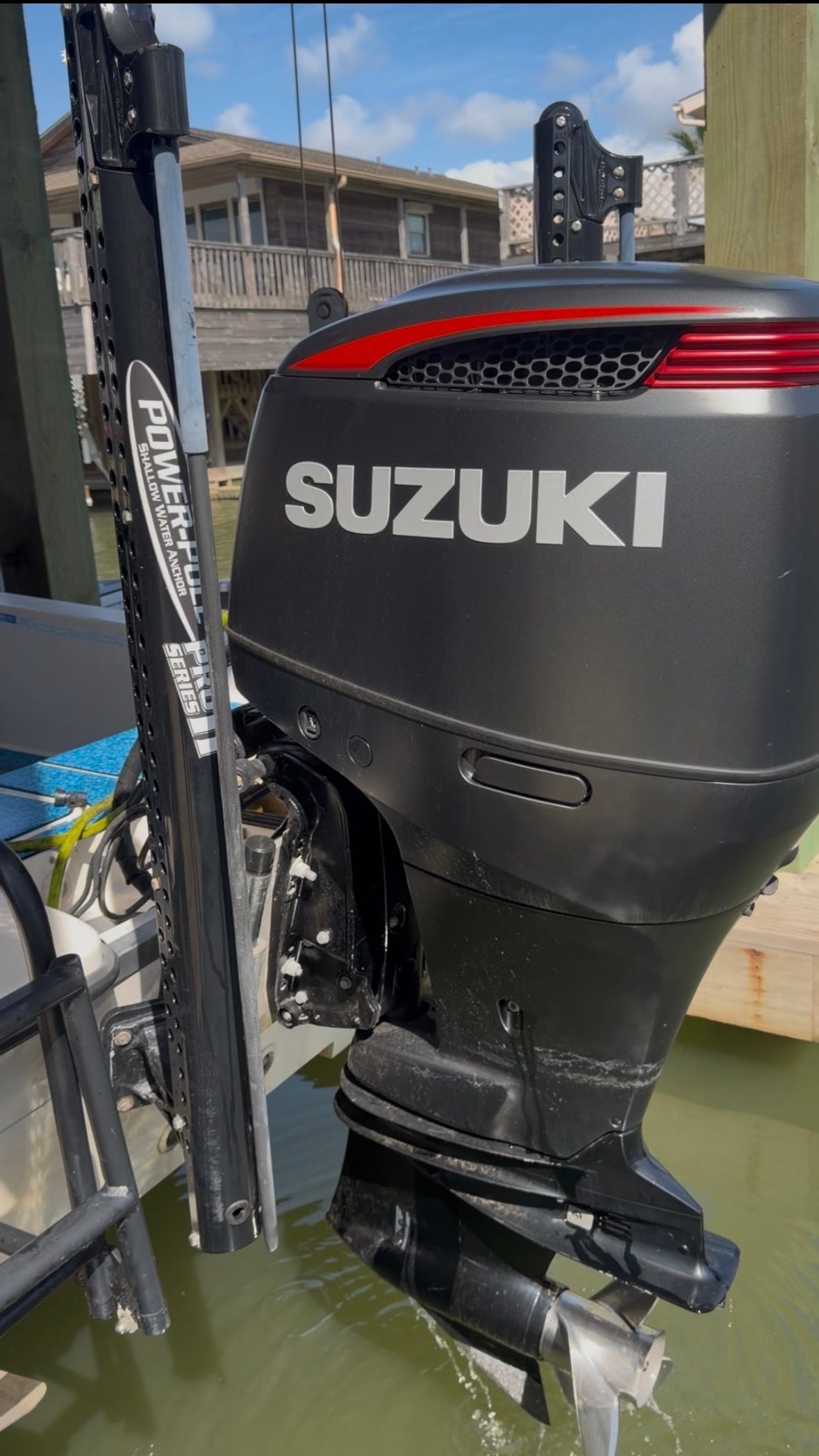A Suzuki outboard motor on a boat docked in the water.