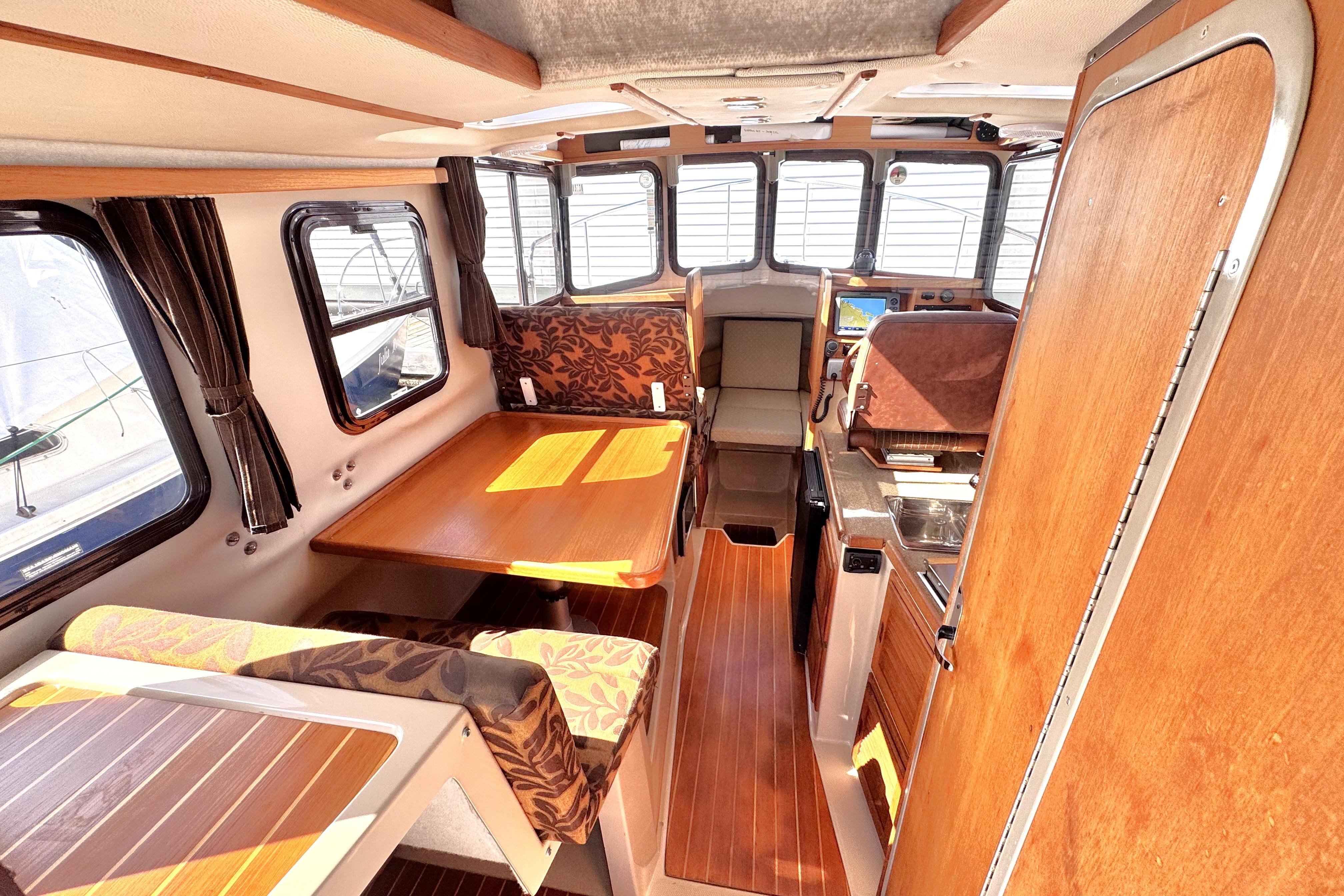 Interior of 2011 Ranger Tugs R-25 boat with wood finishes and seating area.