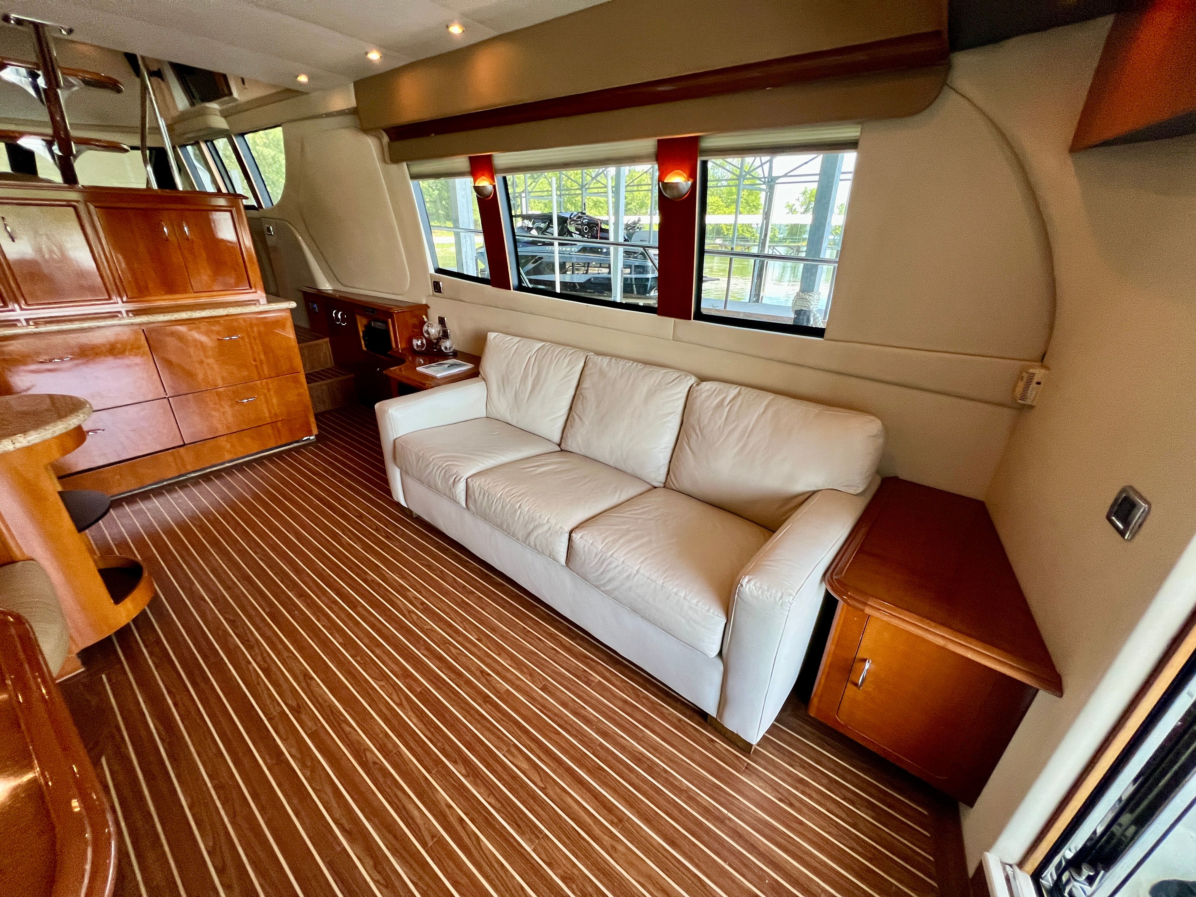 Interior of 2005 Carver 560 Voyager Sky yacht with leather sofa and wooden furniture.