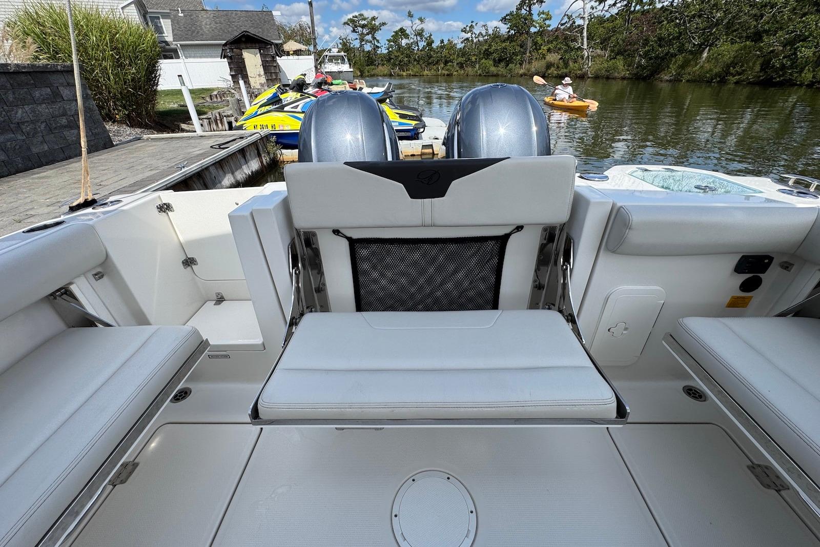 2022 Sailfish 276 DC boat interior with seating, dock, and water view.