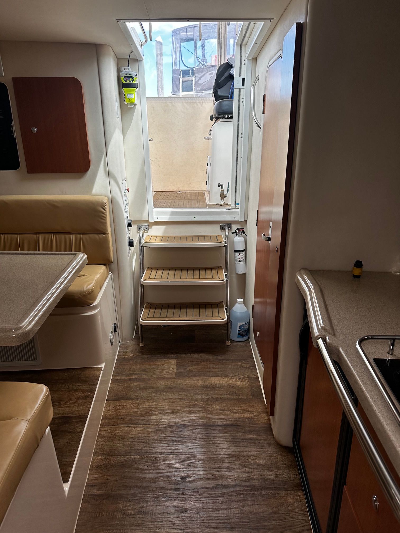 Interior of a Wellcraft 330 Coastal with wood flooring and stairs leading to an exterior door.