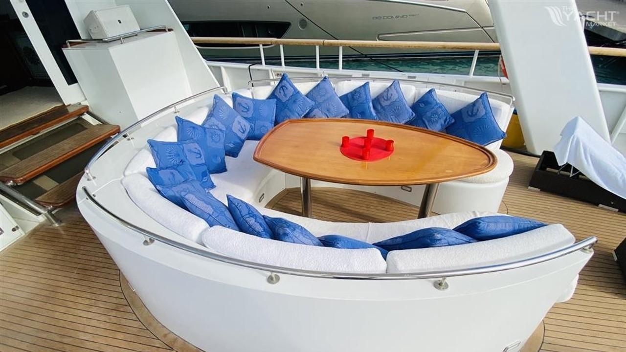 Luxurious seating area on 2005 Explorer Motor Yachts 28M with blue cushions and wooden table.