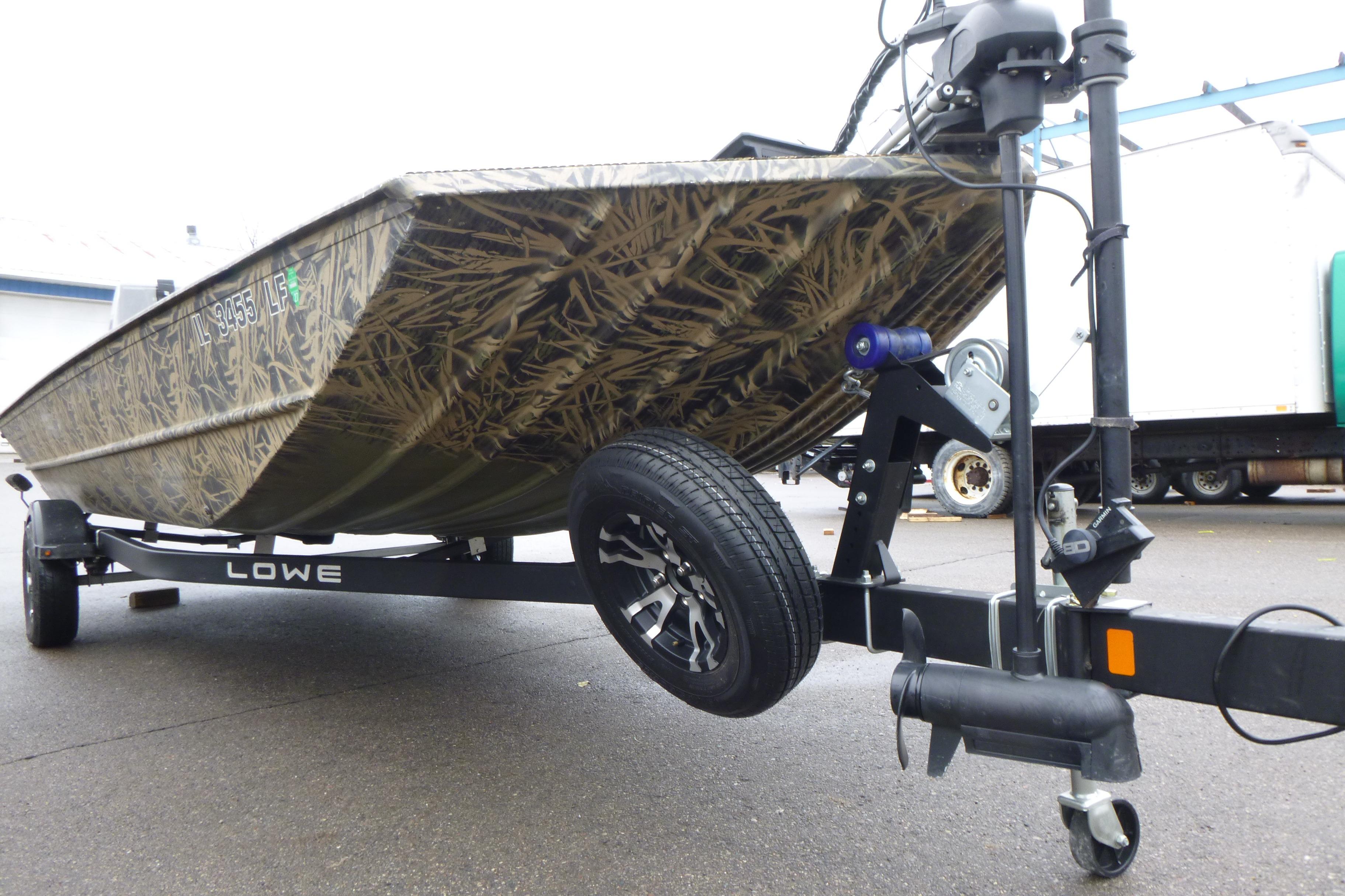 2024 Lowe Roughneck 2070 boat on trailer, featuring camouflage design and sturdy build.