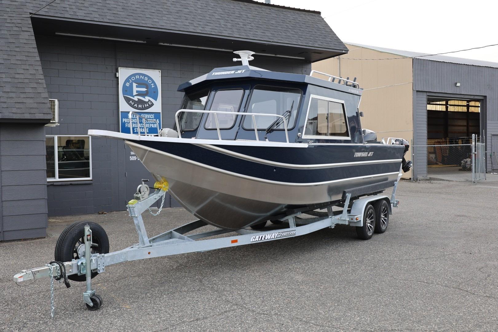 2026 Thunder Jet 24 Alexis Pro boat on trailer outside marine service building.