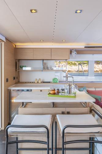 Modern kitchen interior on 2025 Lagoon 60 yacht, featuring sleek design and ample natural light.