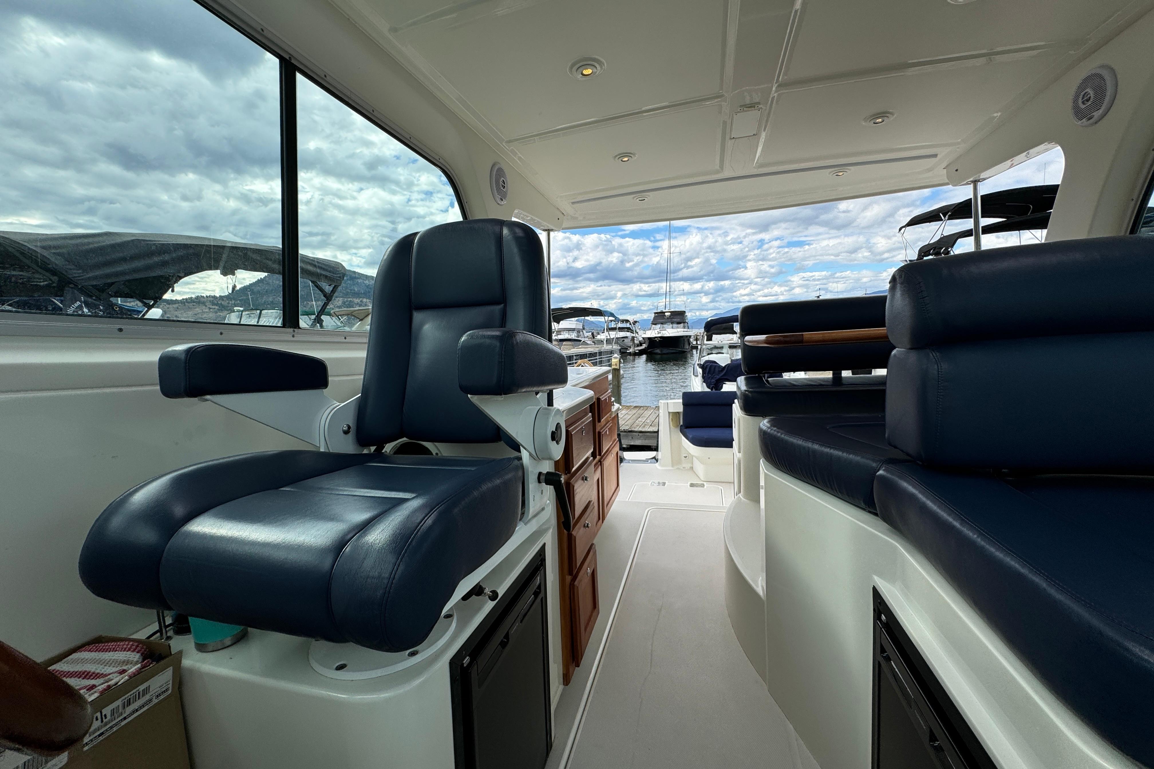Interior of a 2008 Back Cove 33 boat with blue seating and marina view.