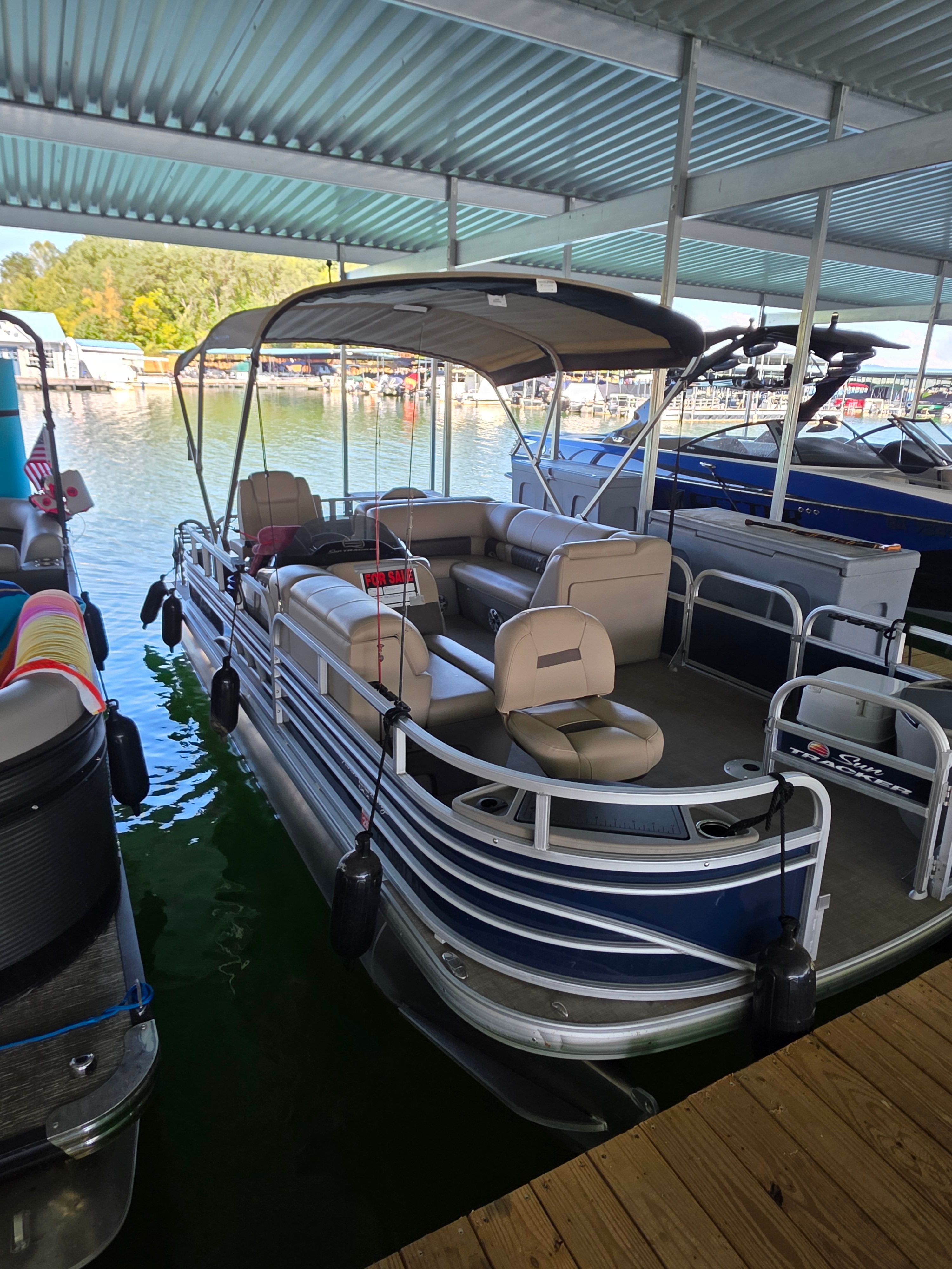 2023 Sun Tracker FB20 pontoon boat docked at marina.