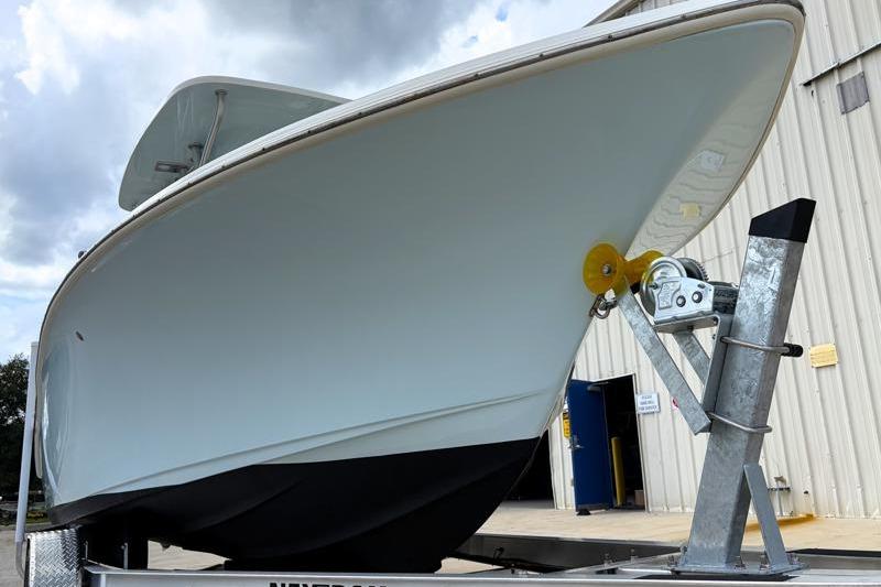 2024 Key West 239 FS boat on trailer, parked near a building under cloudy skies.